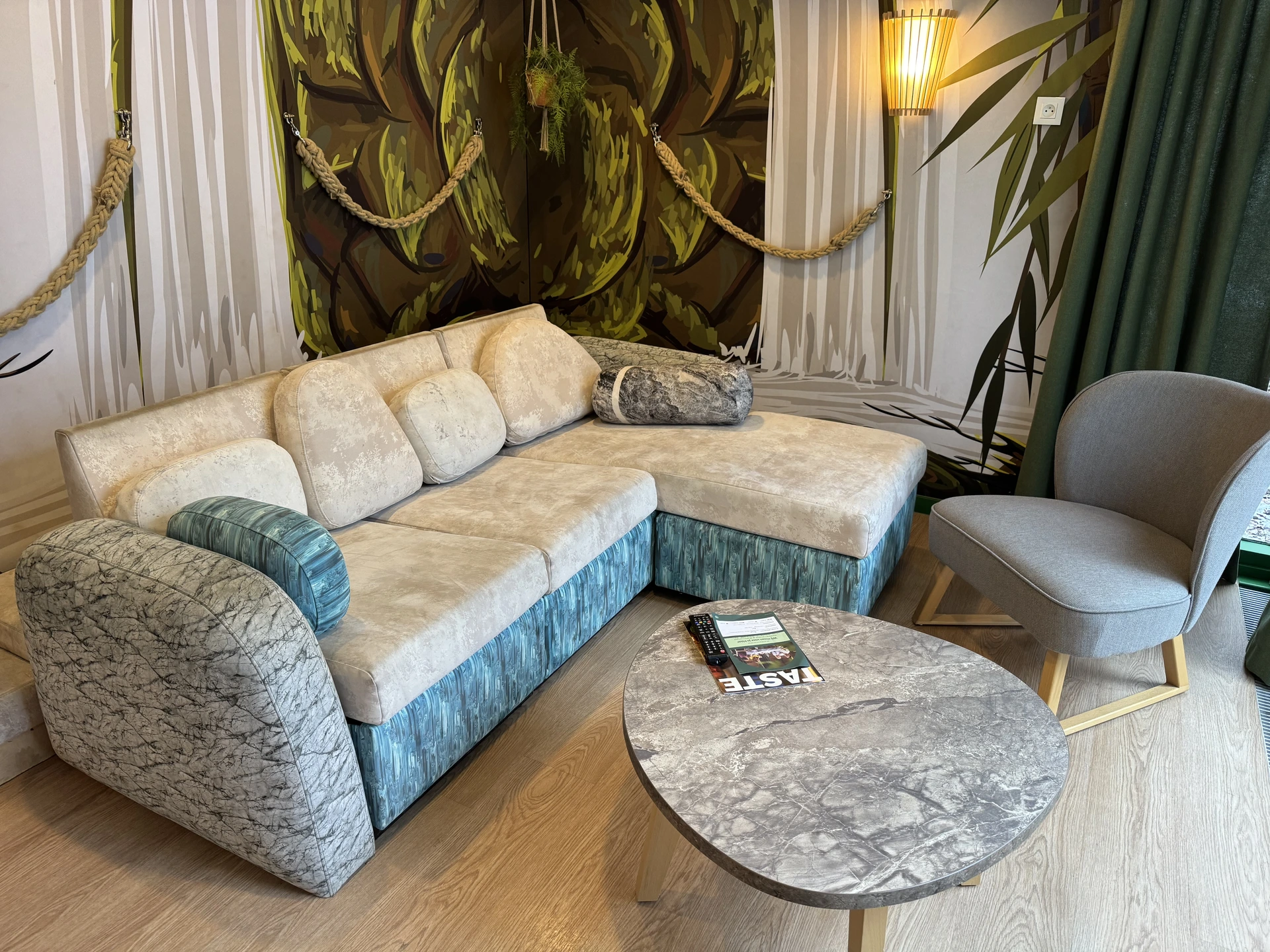 Wohnzimmer im Naturwunder-Ferienhaus im Center Parcs De Vossemeren mit Dschungel-Tapete und Lianen