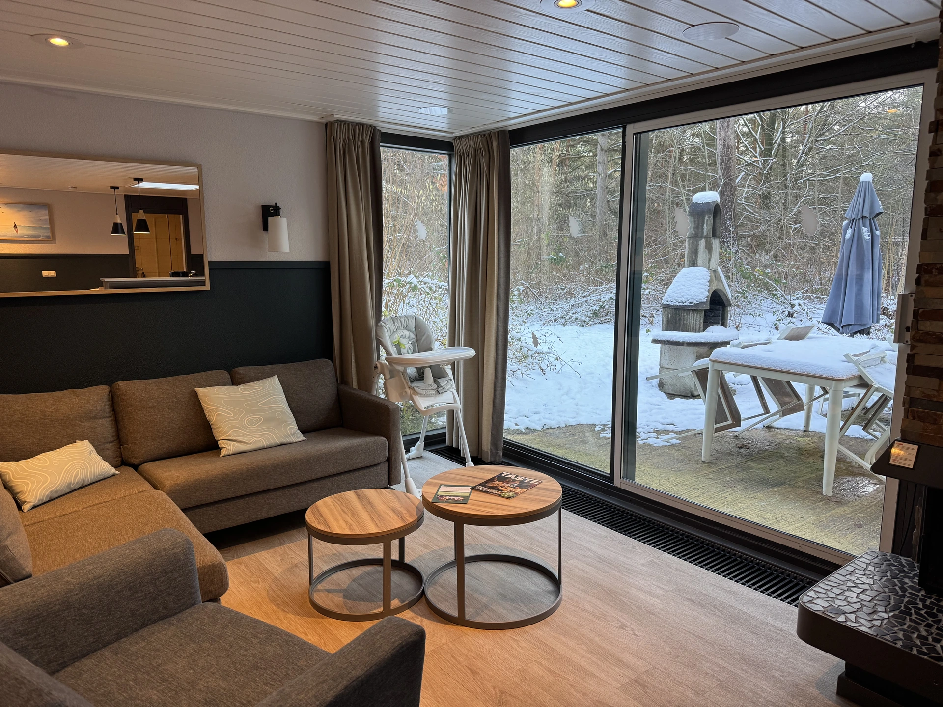 Wohnzimmer im VIP Ferienhaus im Center Parcs De Vossemeren mit Blick in den verschneiten Garten