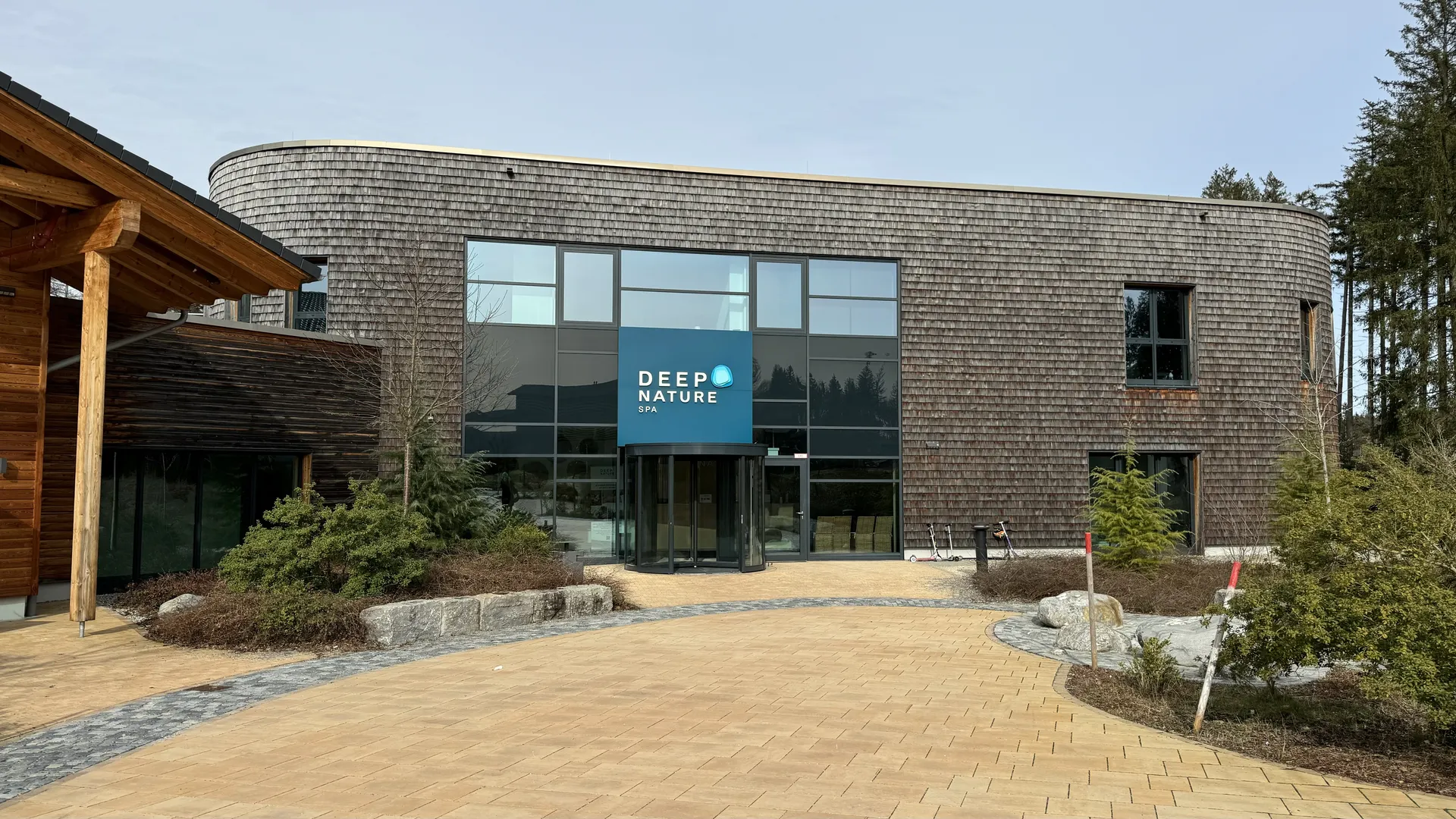 Eingang des Deep Nature Spa im Center Parcs Park Allgäu mit DEEP NATURE Schriftzug und Holzfassade