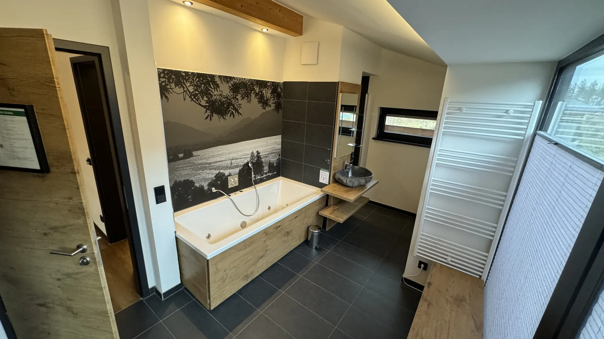 Wellnessbad mit Whirlpool und Naturstein-Wand