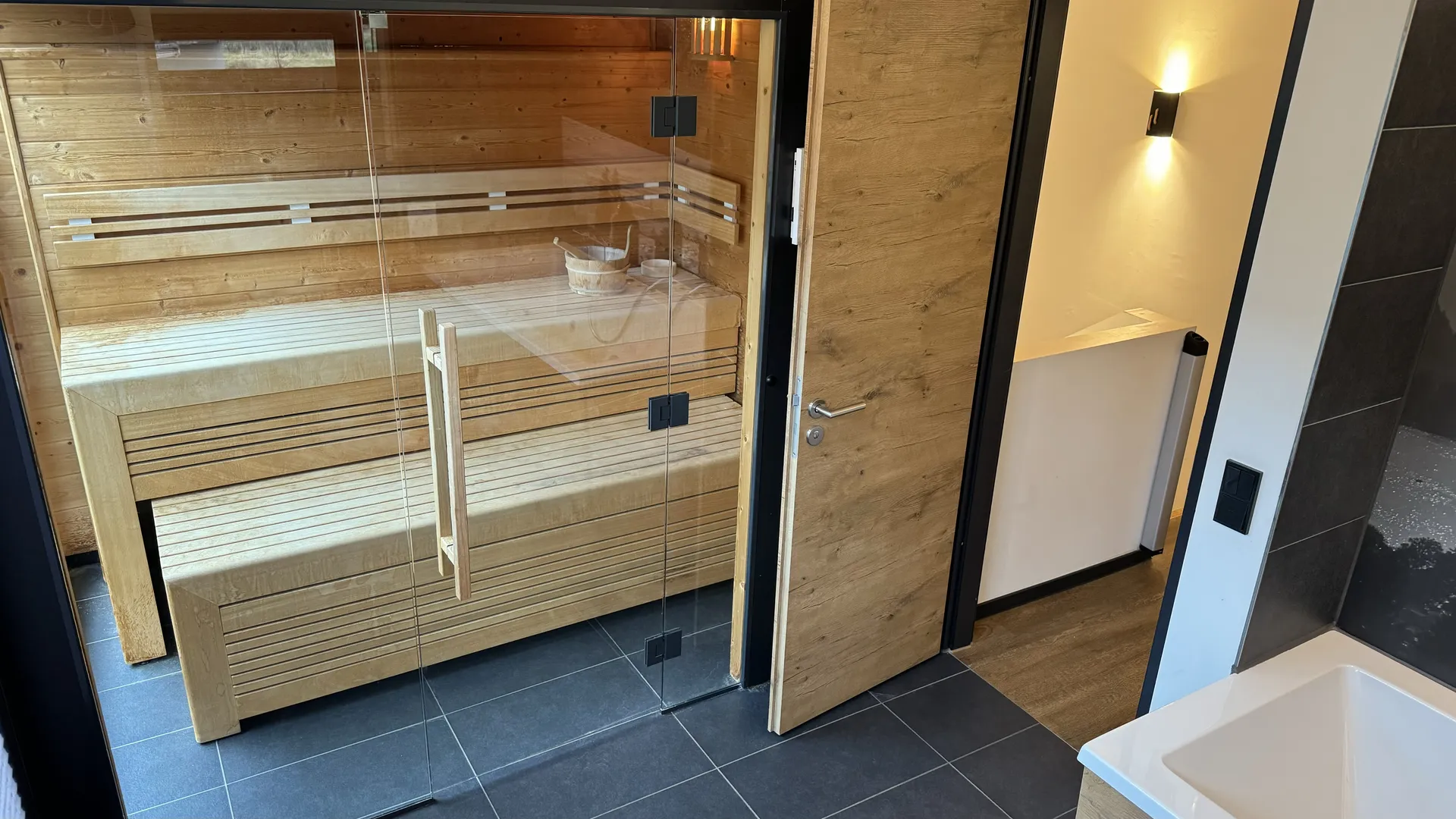 Finnische Sauna im Exclusive-Ferienhaus mit Holzbänken und Saunaofen