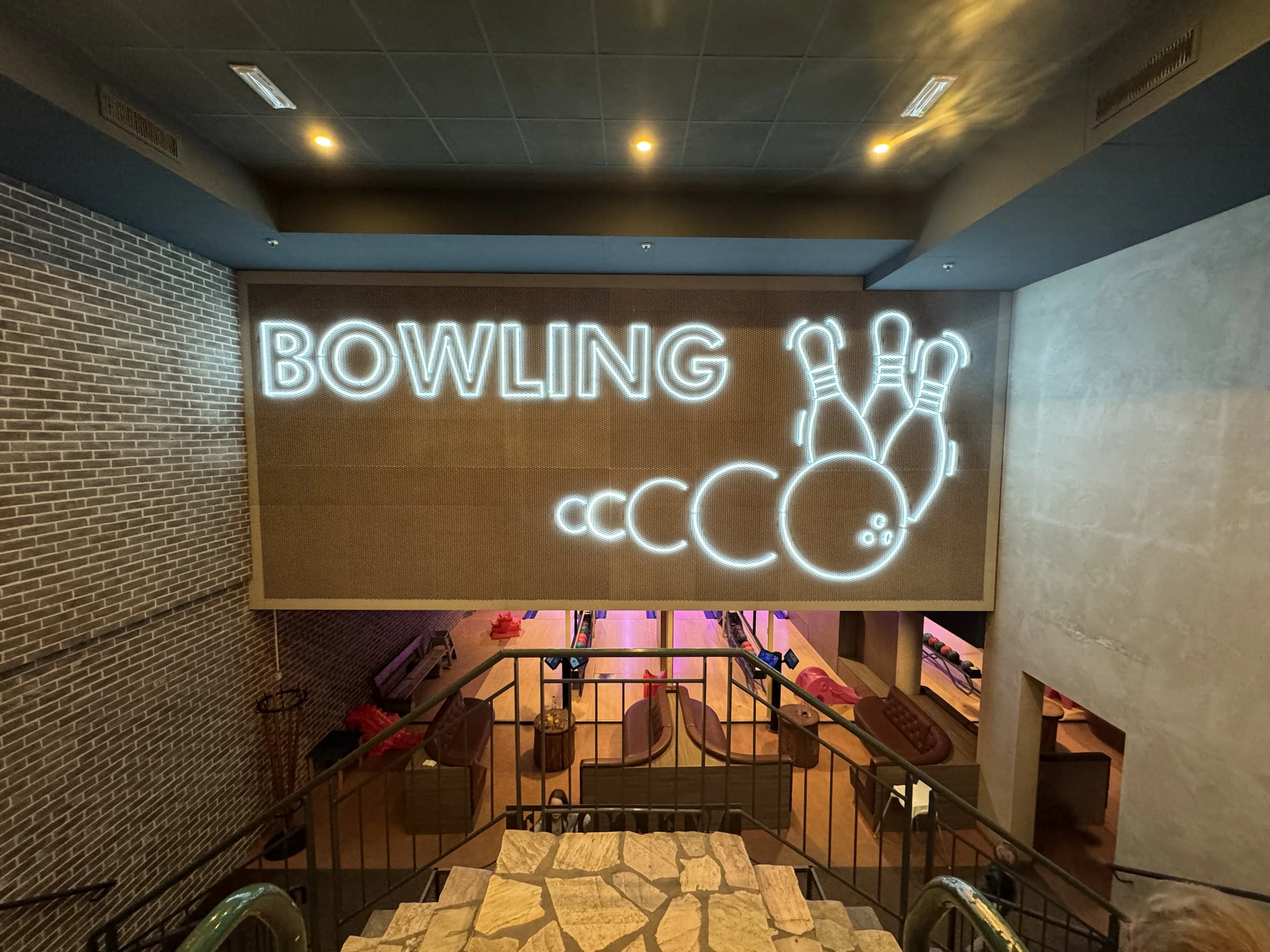 Die Bowling-Neon-Leuchte weist den Weg ins Untergeschoss