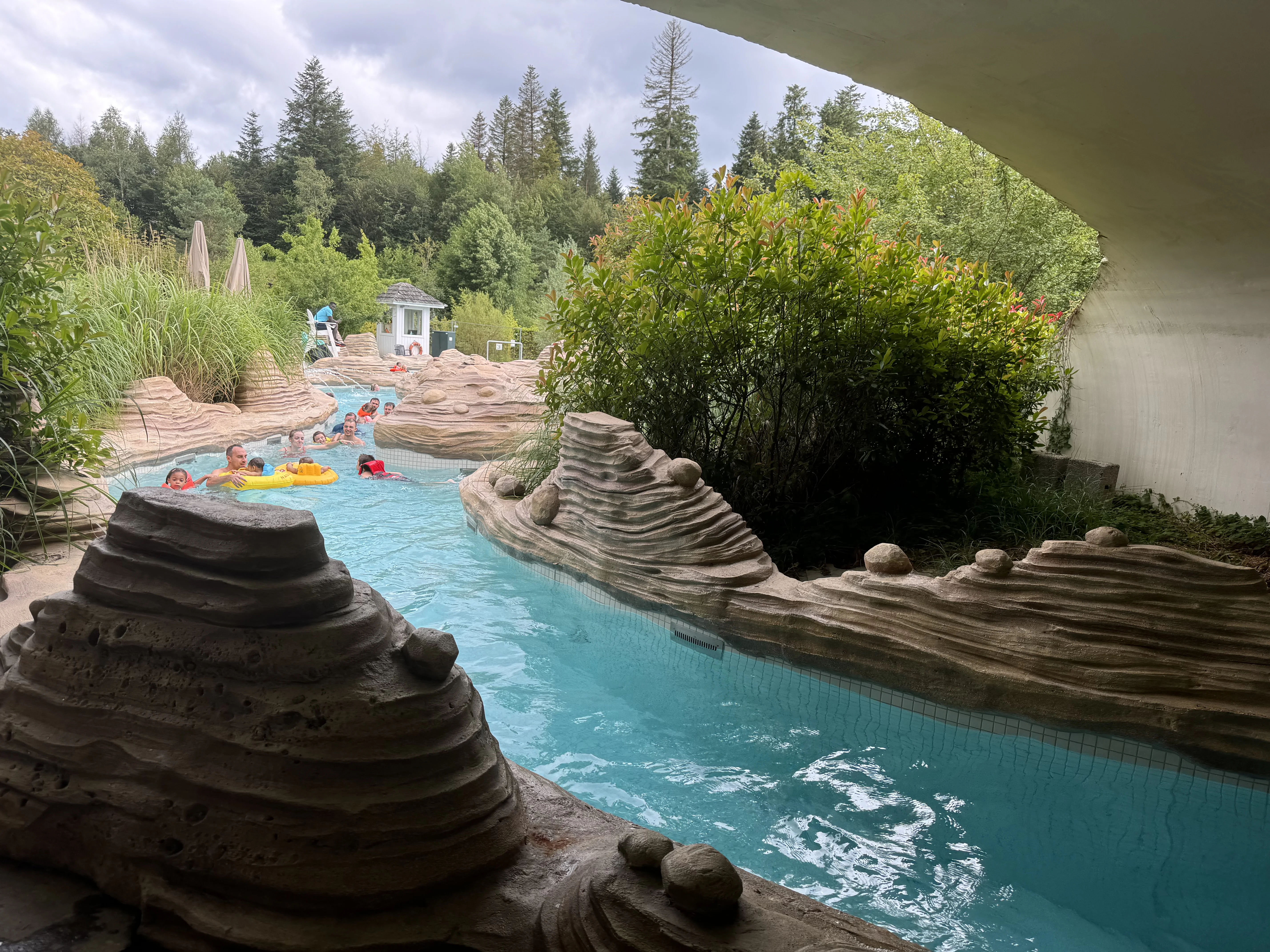 Außenbereich des Aqua Mundo im Center Parcs Les Trois Forêts mit Becken und Liegewiese