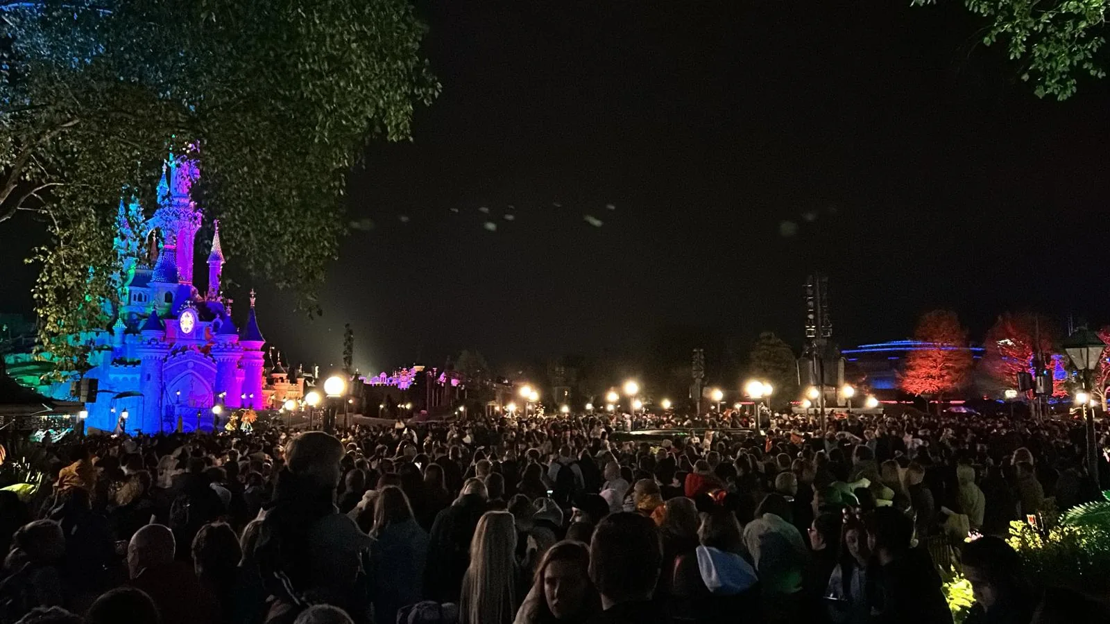 Das beleuchtete Dornröschenschloss beim Feuerwerk am Abend mit großer Menschenmenge