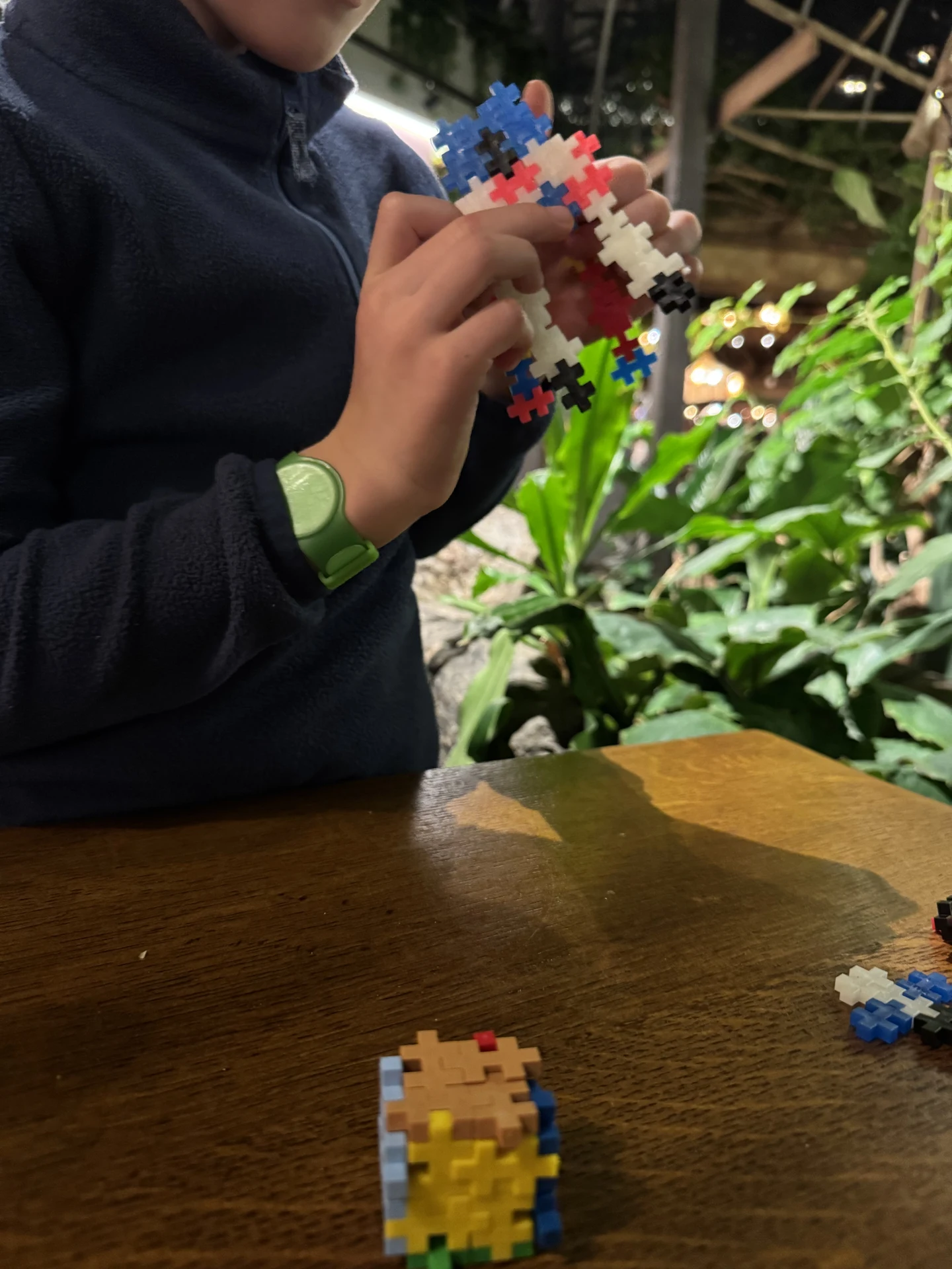Grünes Center Parcs Armband am Handgelenk eines Kindes beim Spielen im Ferienpark