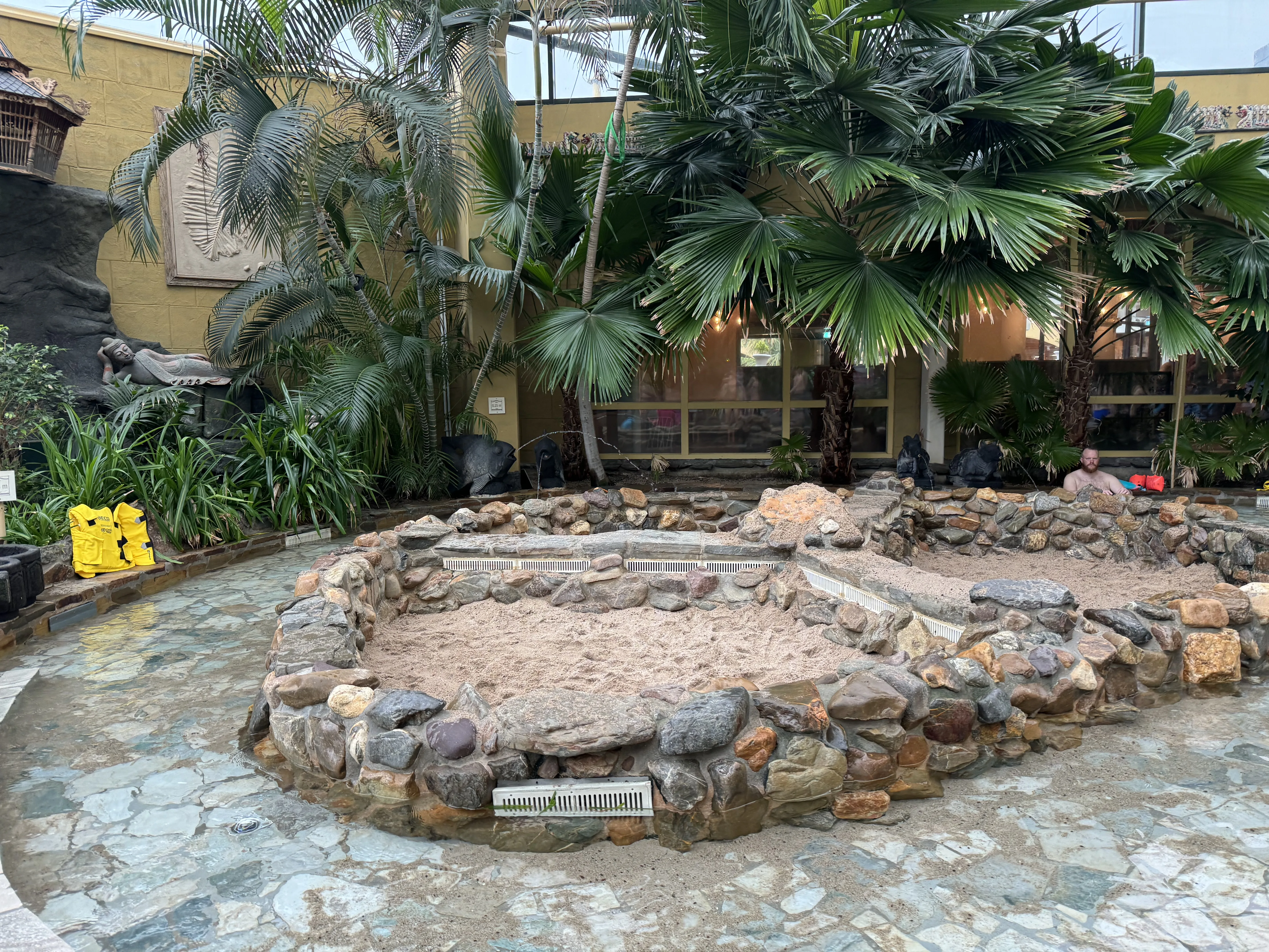 Der Kleinkinder-Spielbereich – ein Sandkasten unter Palmen neben dem Wasserbecken