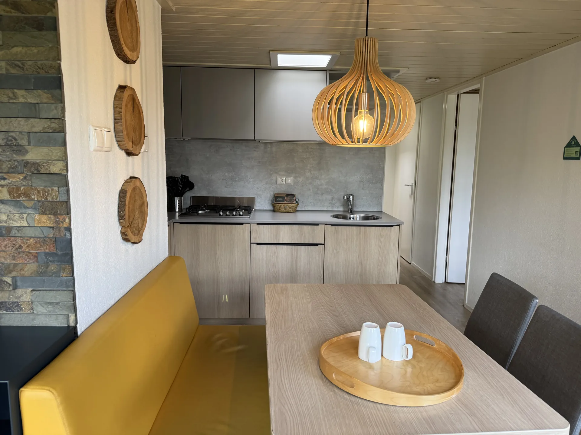 Essbereich mit Schieferwand und Holzscheiben-Deko im VIP-Ferienhaus für 4 Personen