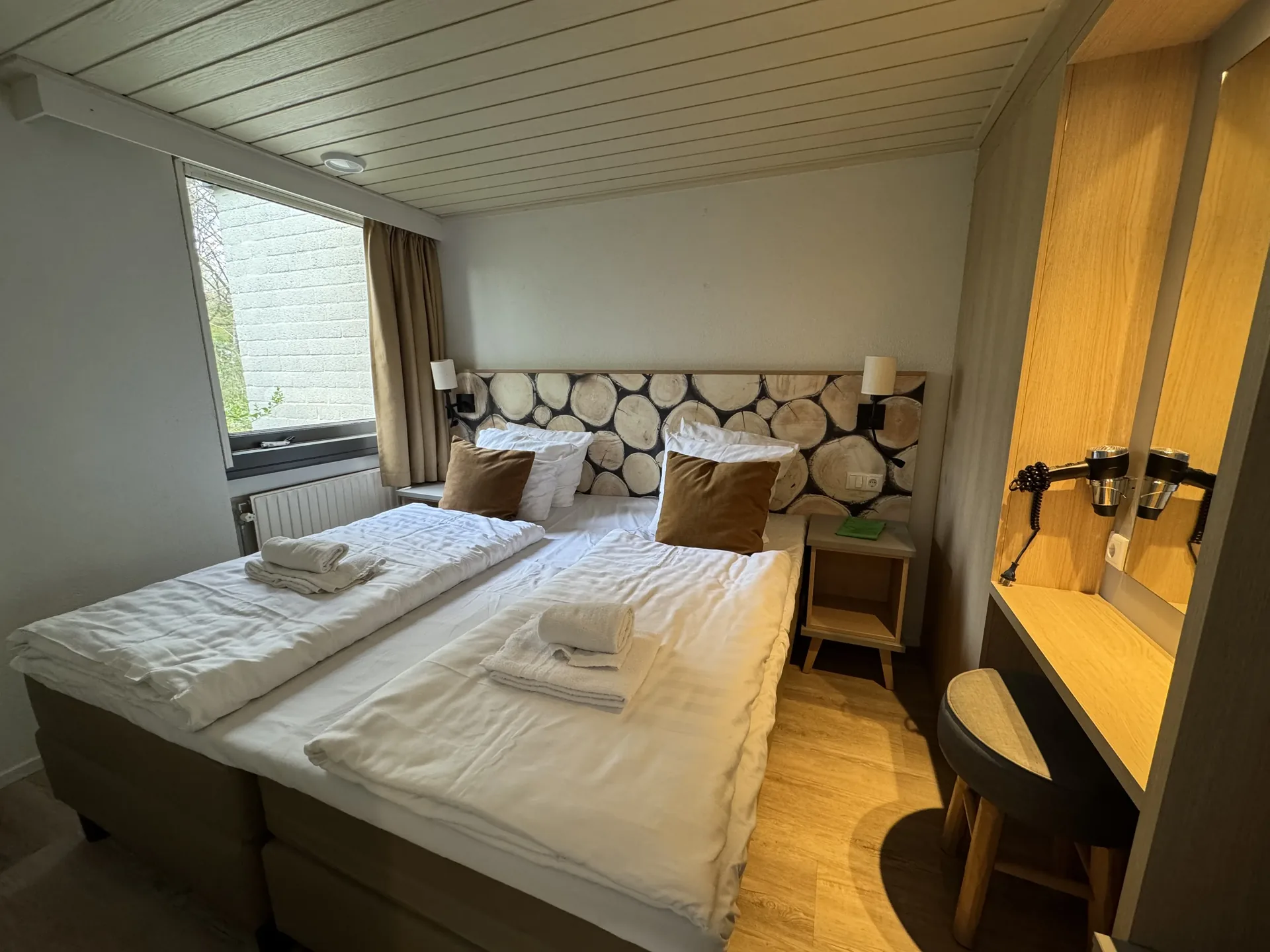 Elternschlafzimmer im VIP-Ferienhaus für 4 Personen mit Kopfteil aus Holzscheiben und Schminktisch