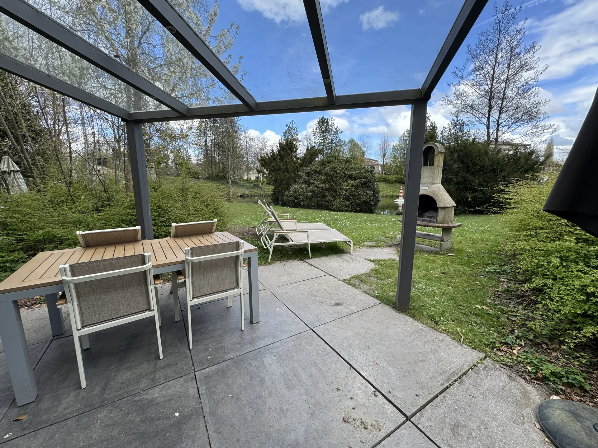 Glasdach über der Terrasse des VIP-Ferienhauses für 4 Personen mit Esstisch und Liegen