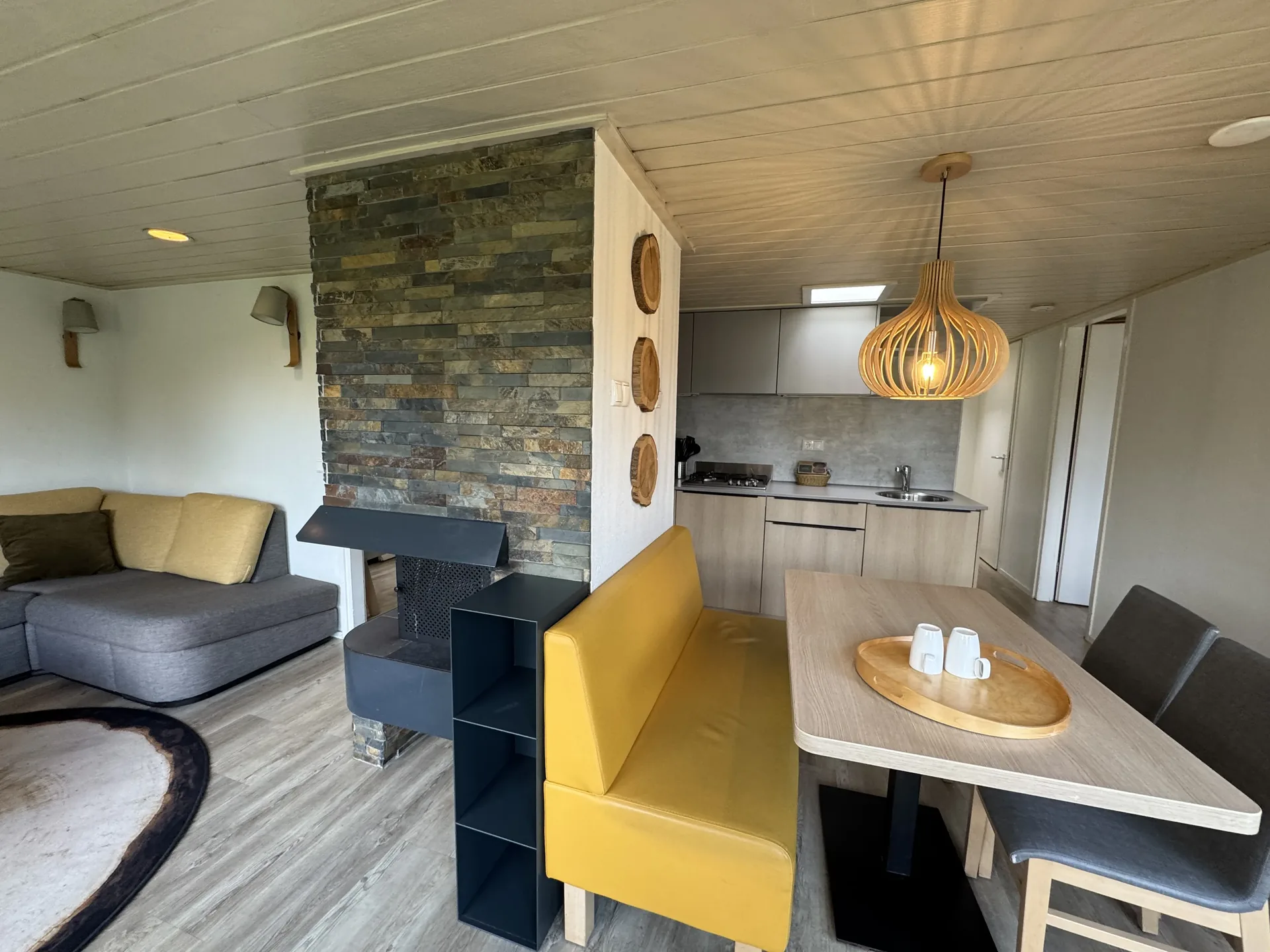 Blick vom Wohnbereich über den Kamin zur offenen Küche im VIP-Ferienhaus für 4 Personen