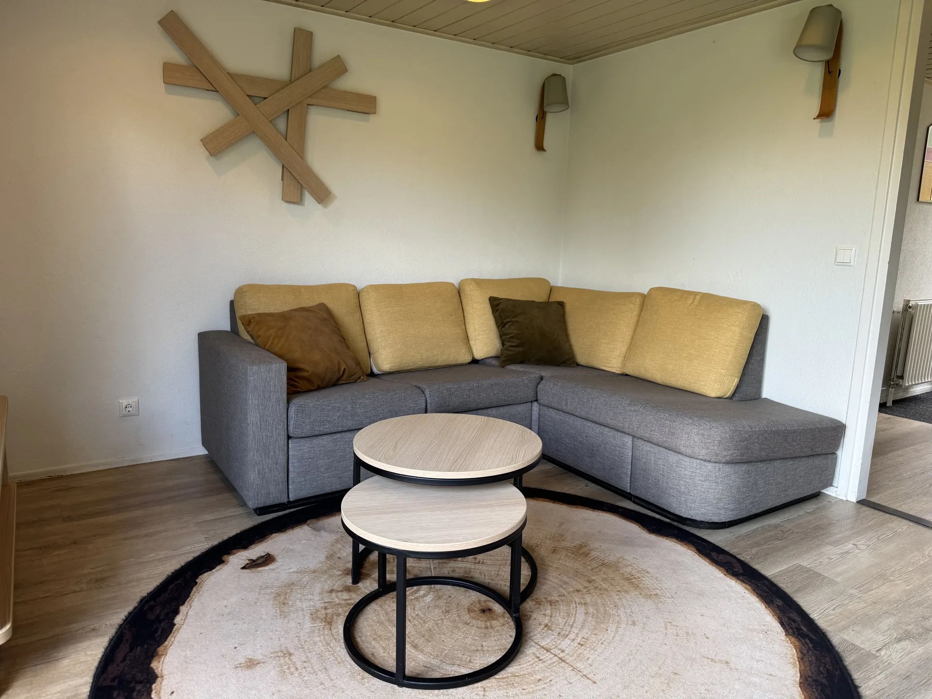 Ecksofa mit Beistelltischen und rundem Teppich im VIP-Ferienhaus für 4 Personen