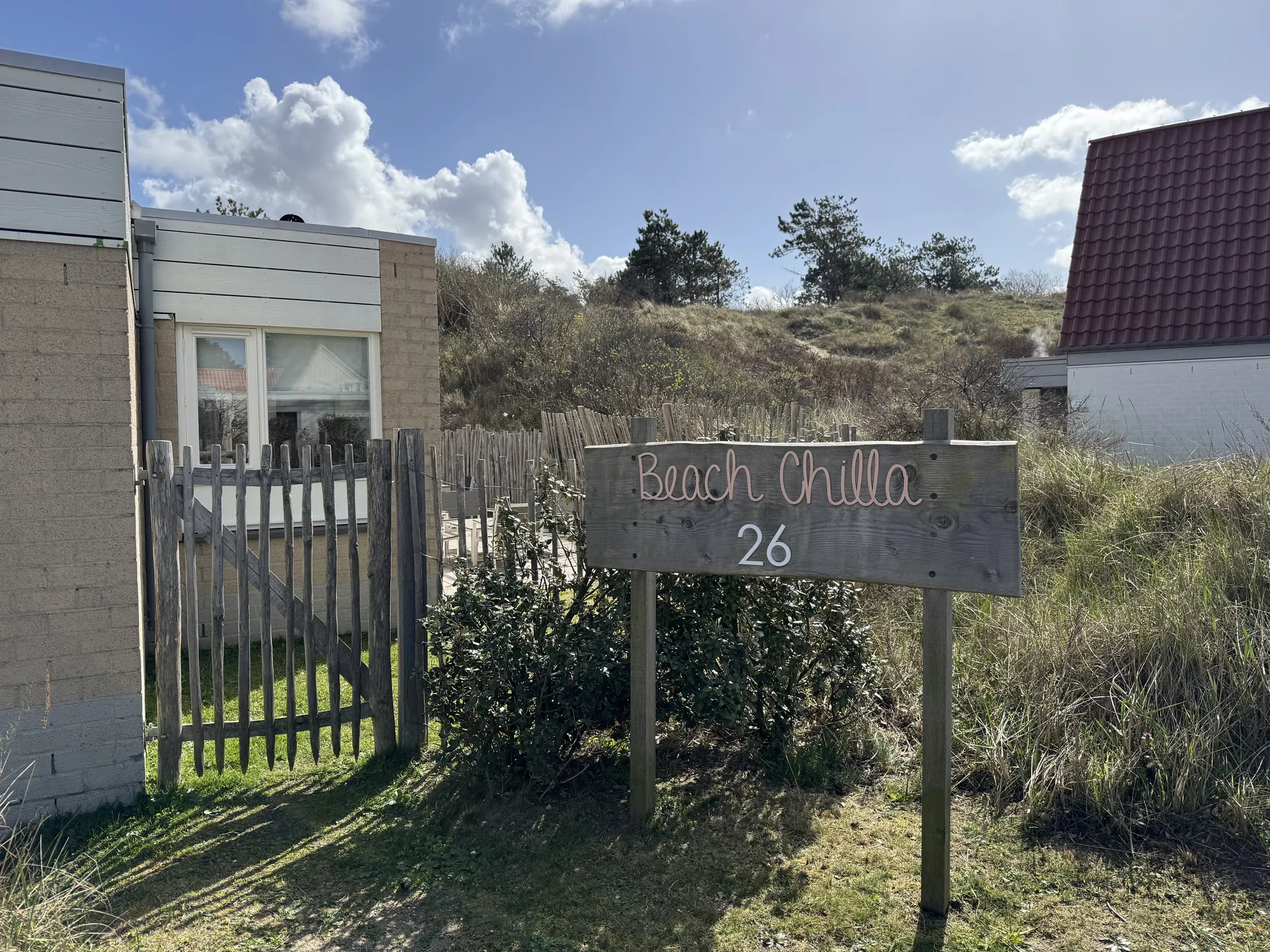 Beach Chilla Ferienhaus im Center Parcs Park Zandvoort mit Eingangsschild und Dünen