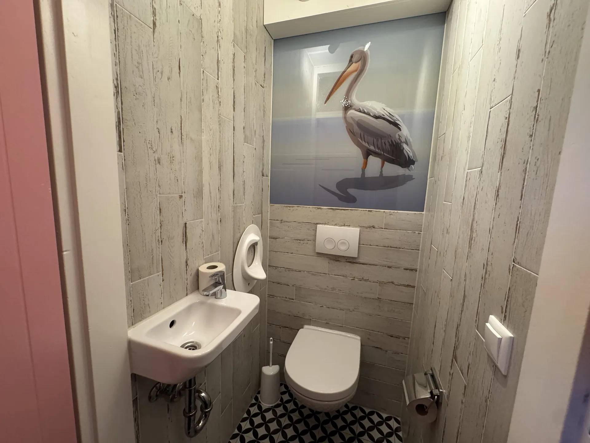 Gäste-WC mit Pelikan-Wandbild, Toilette und kleinem Waschbecken