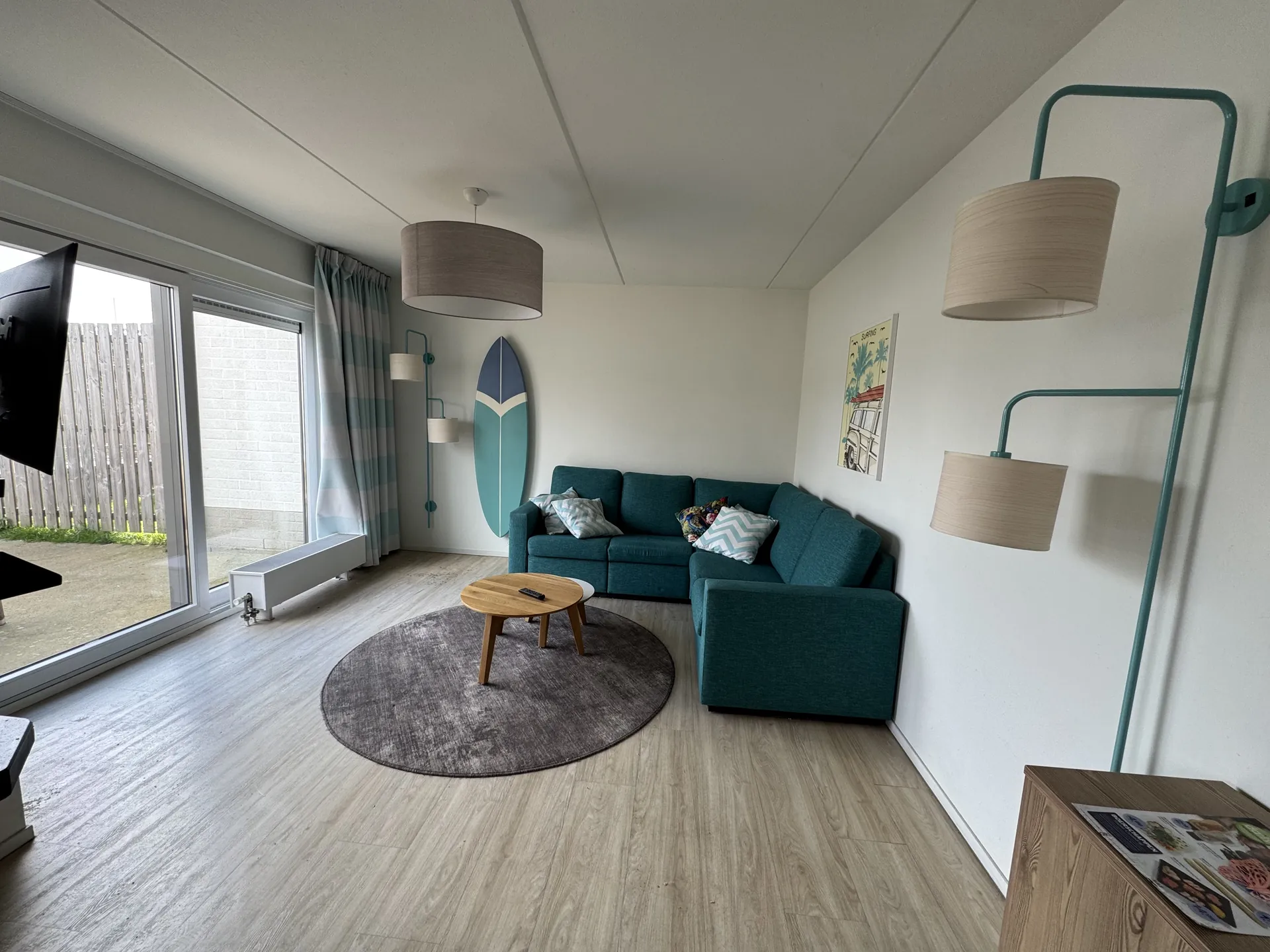 Wohnzimmer in der Surf-Variante mit Sofa und Deko-Surfbrett an der Wand