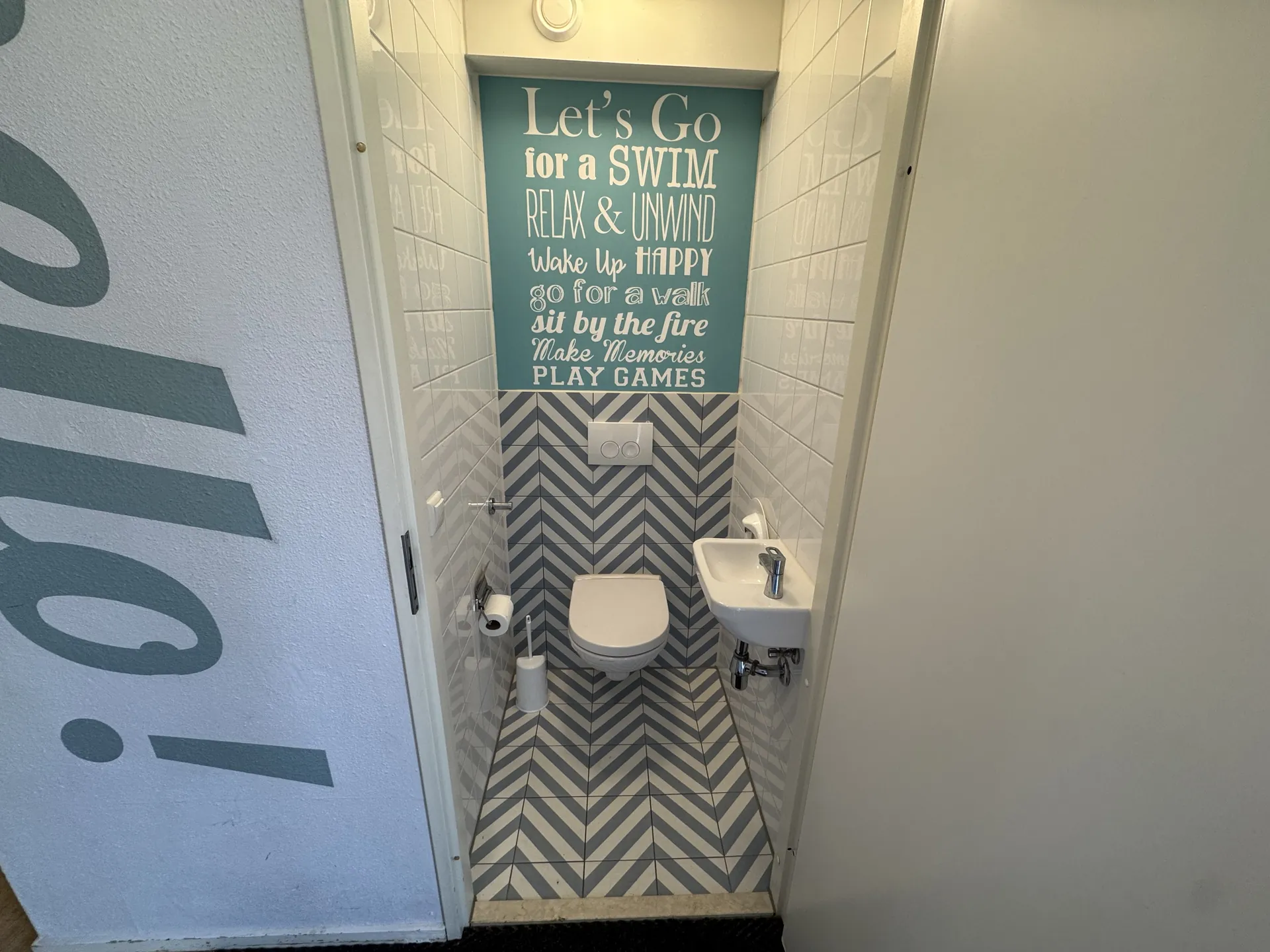 Gäste-WC mit modernen Fliesen und farbiger Akzentwand