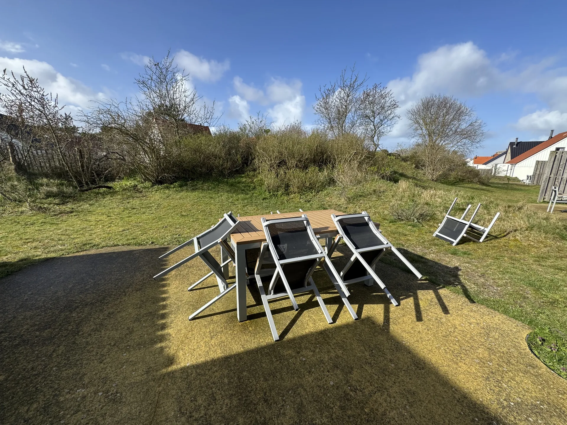 Gartensitzgruppe mit Klapptisch und Stühlen vor der Dünenlandschaft