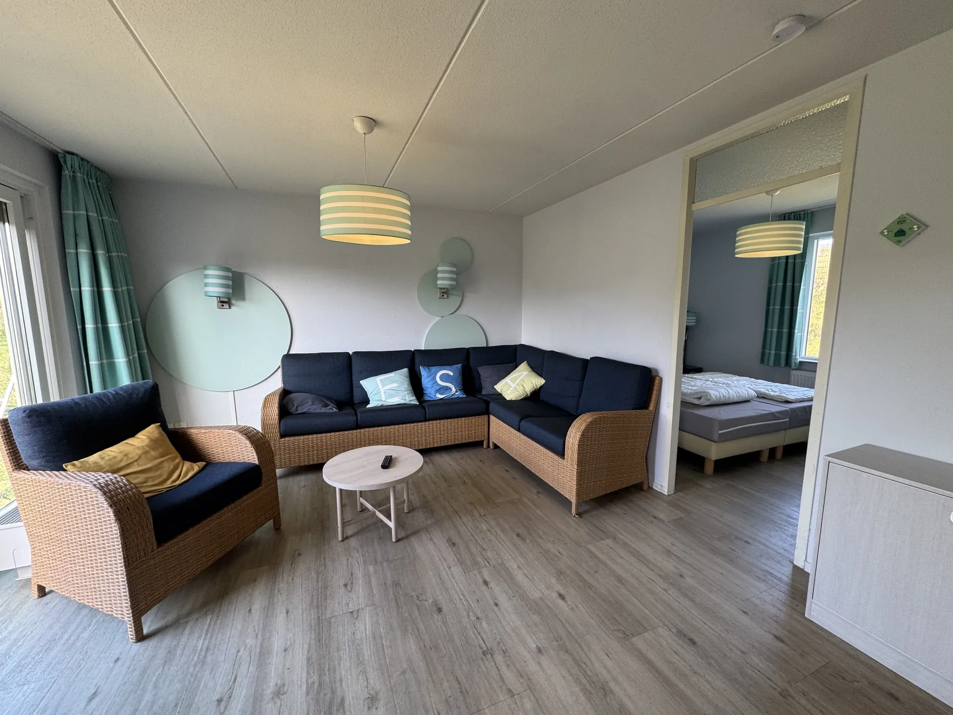 Wohnzimmer im Comfort-Ferienhaus mit Eckcouch, Sessel und maritimer Einrichtung