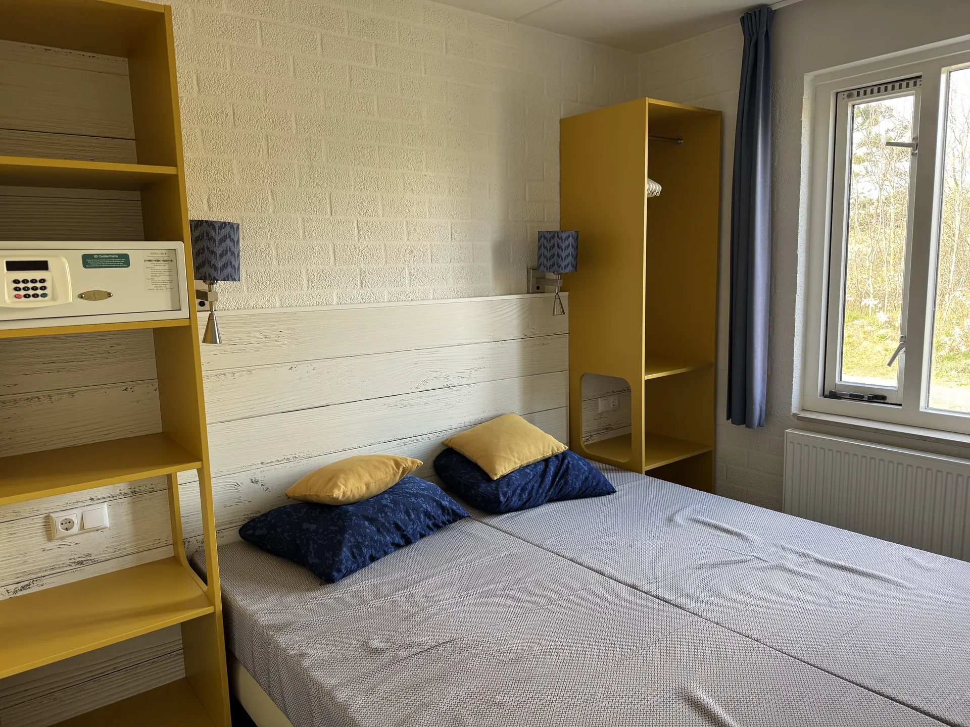 Schlafzimmer mit Doppelbett, Regal und Safe