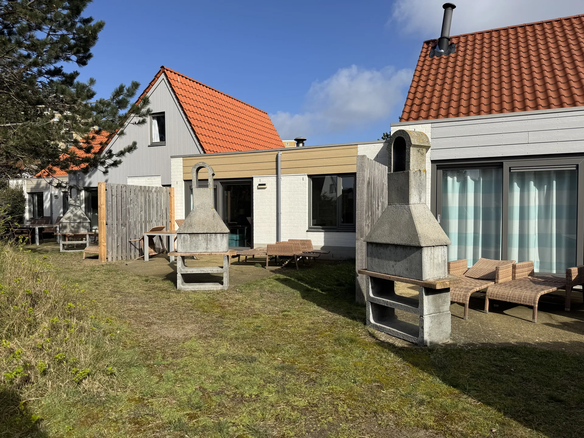 Außenansicht der VIP-Ferienhäuser mit orangefarbenen Dächern und Holzverkleidung