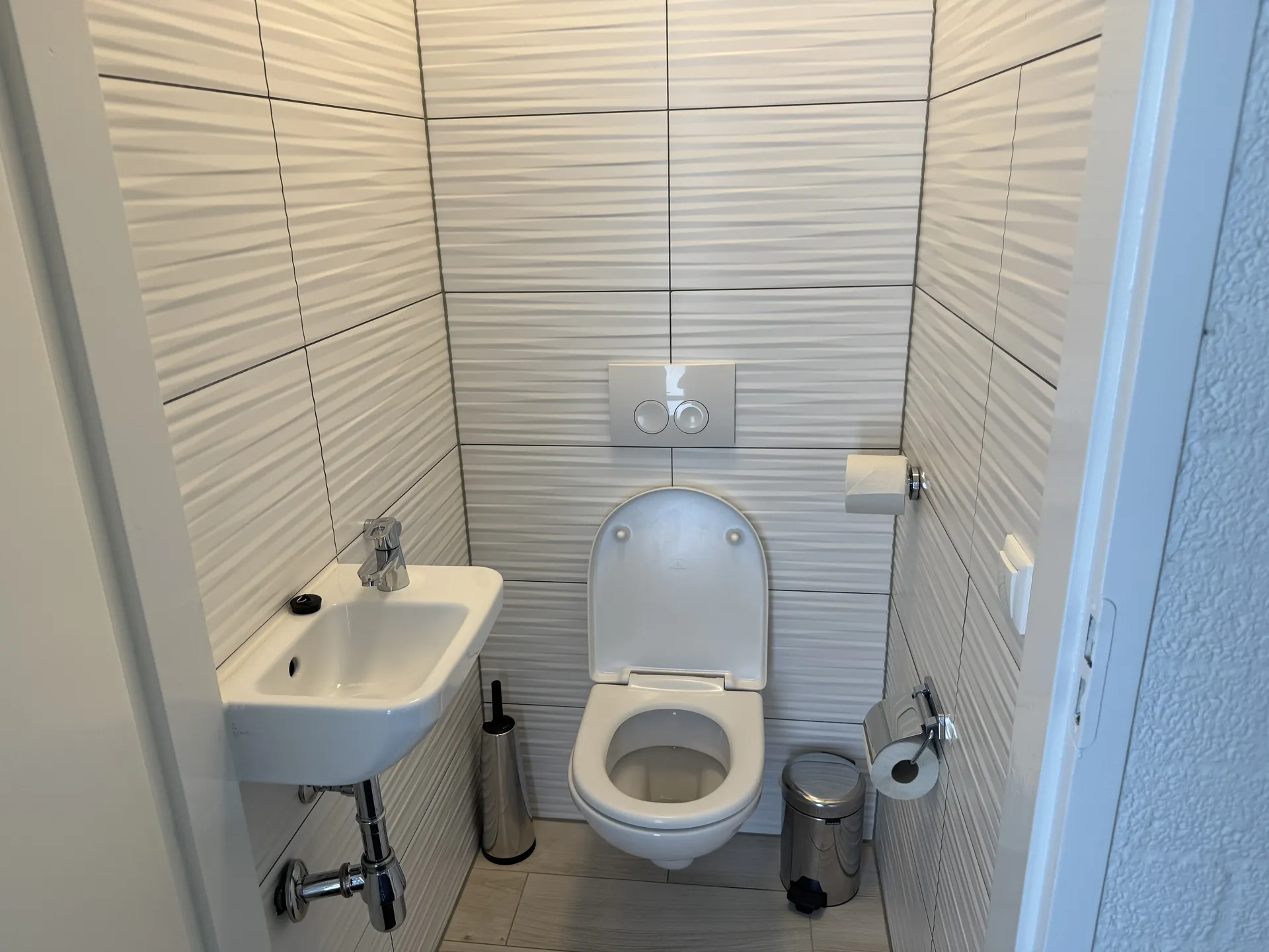 Separates Gäste-WC mit wandhängendem WC und kleinem Handwaschbecken