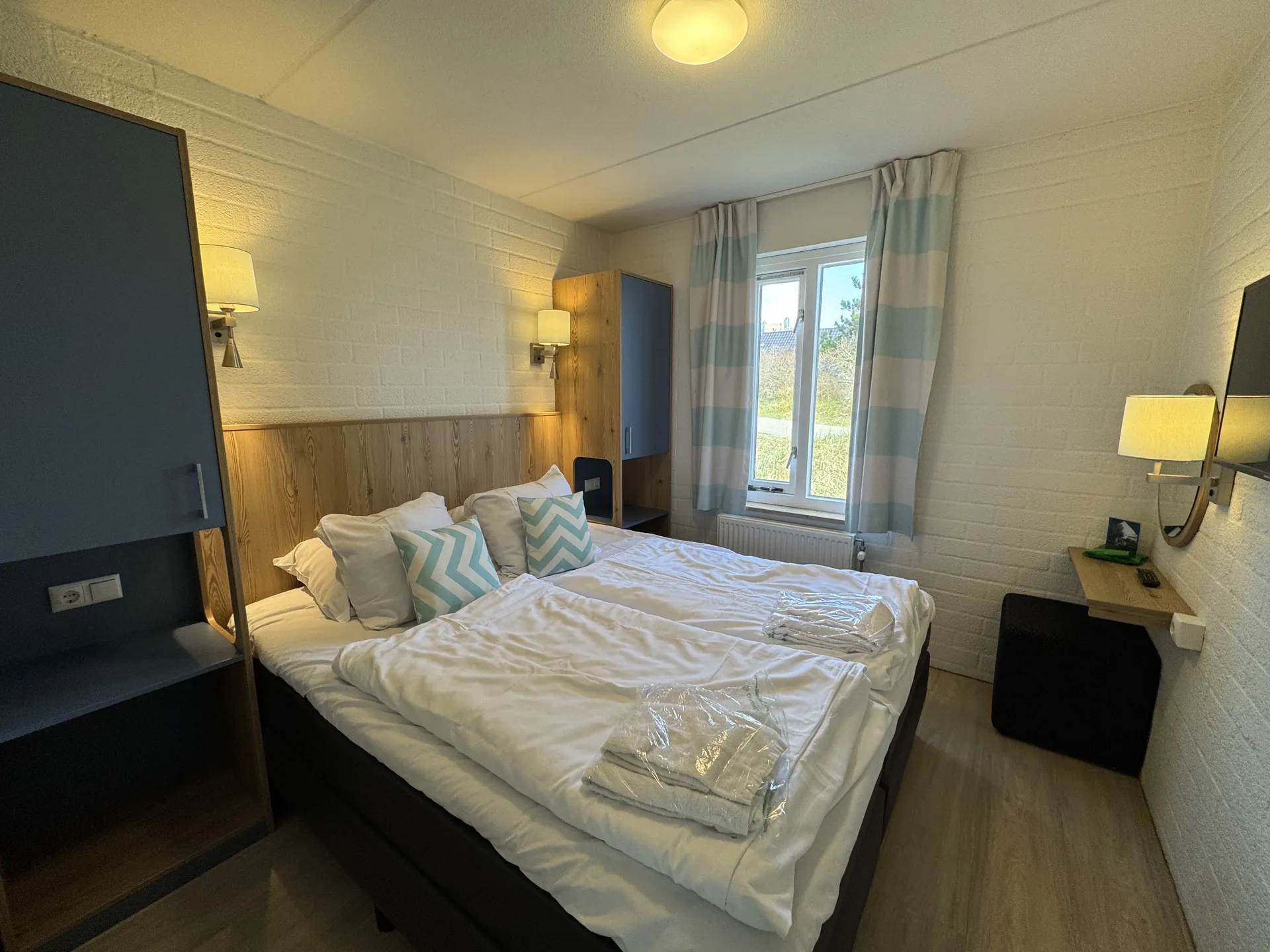 Zweites Schlafzimmer mit Doppelbett, Fernseher und Blick aus dem Fenster