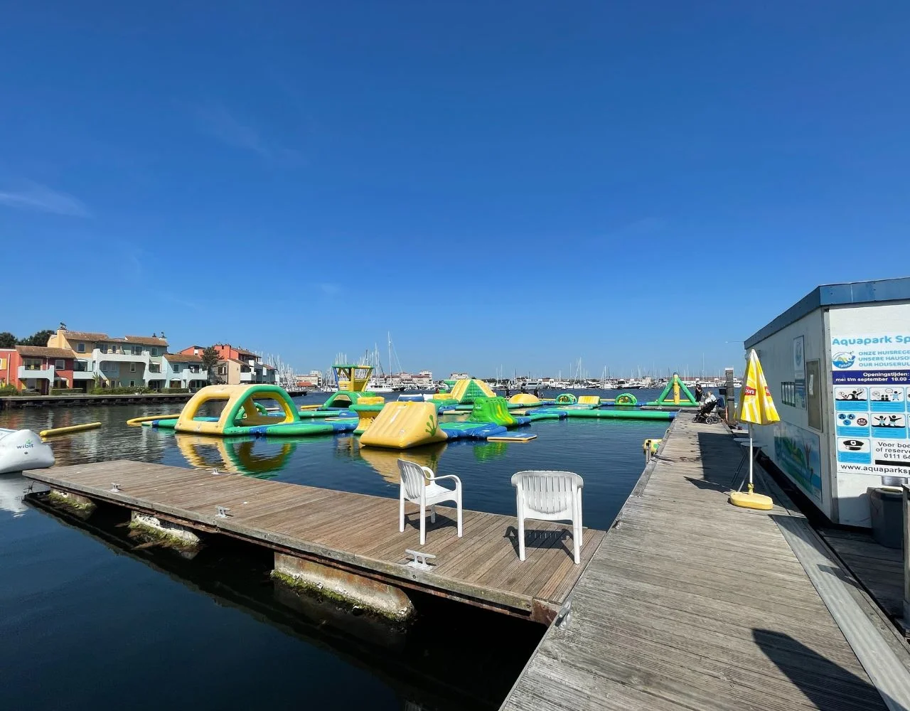 Aquapark im Hafen vom Steg aus mit Inflatable-Parcours auf dem Wasser