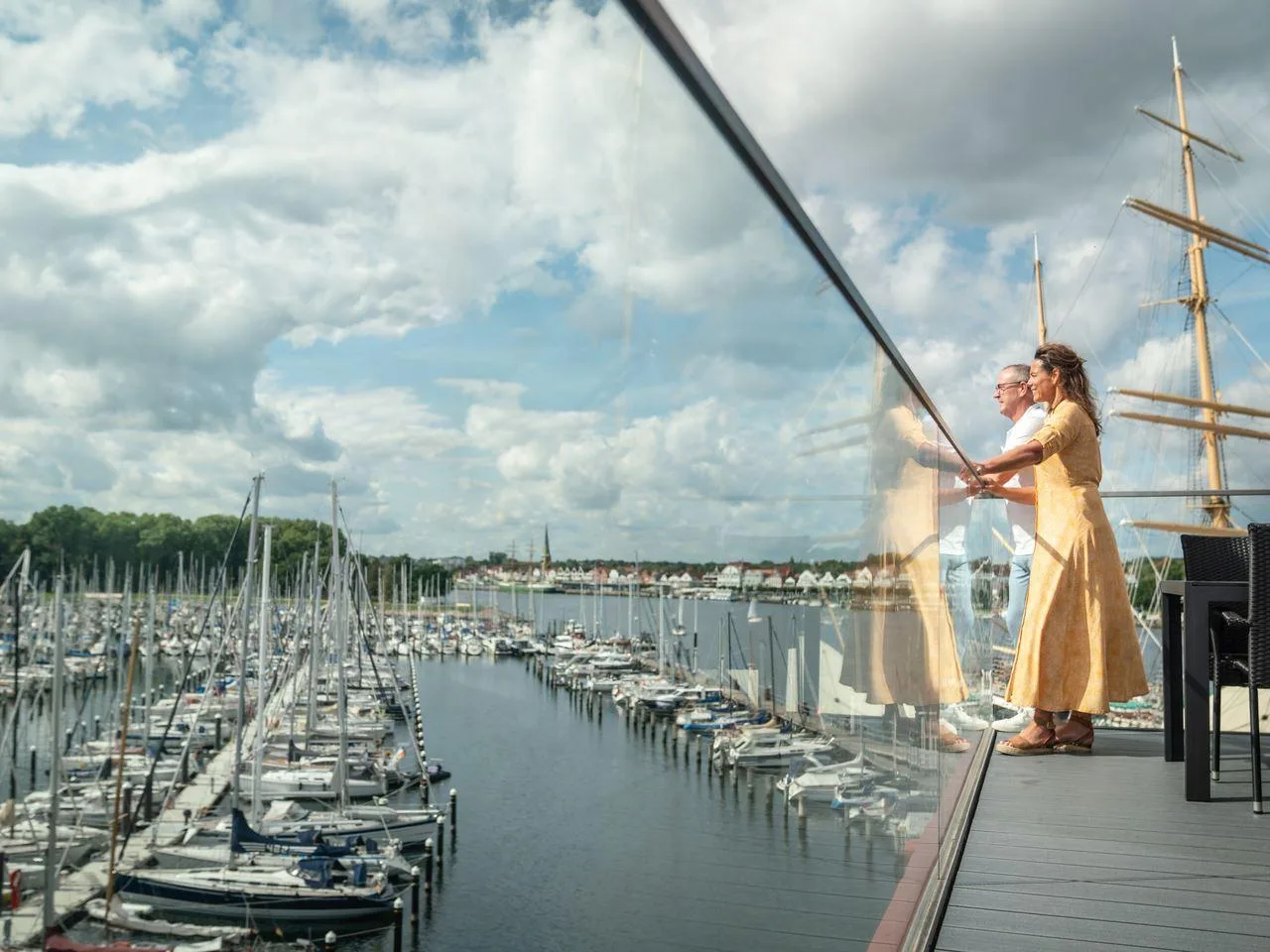 Paar auf dem Balkon mit Hafenblick