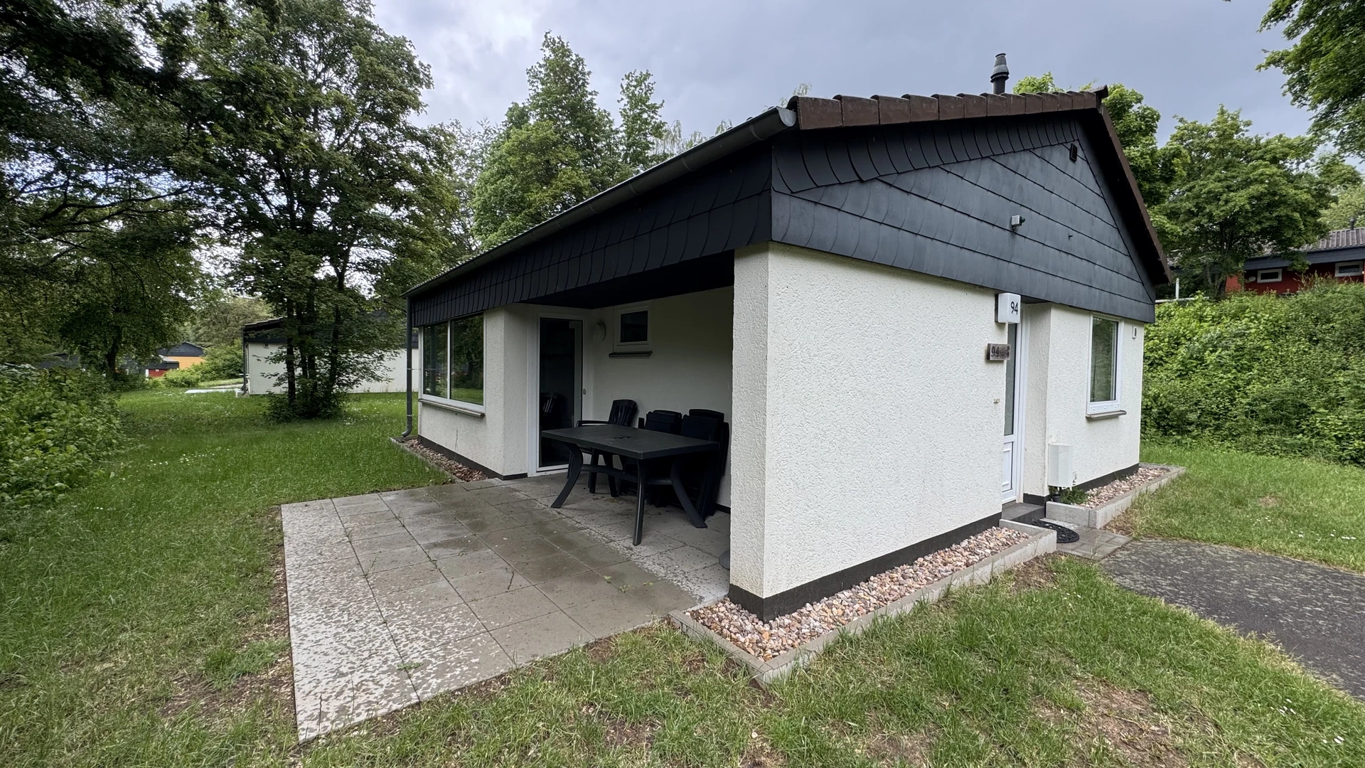 Terrasse im Ferienhaus 94 mit Gartenmöbeln und Blick ins Grüne