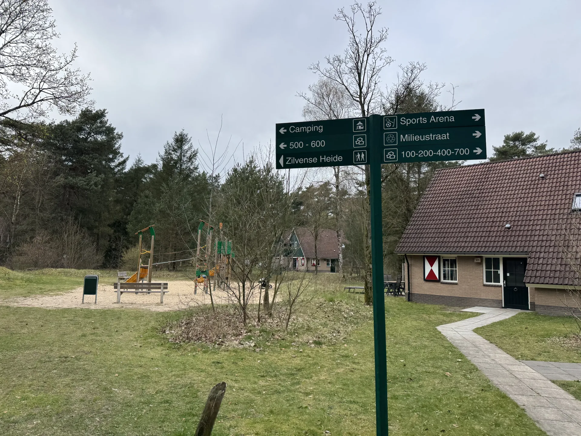 Kleiner Spielplatz zwischen den Ferienhäusern mit Wegweiser