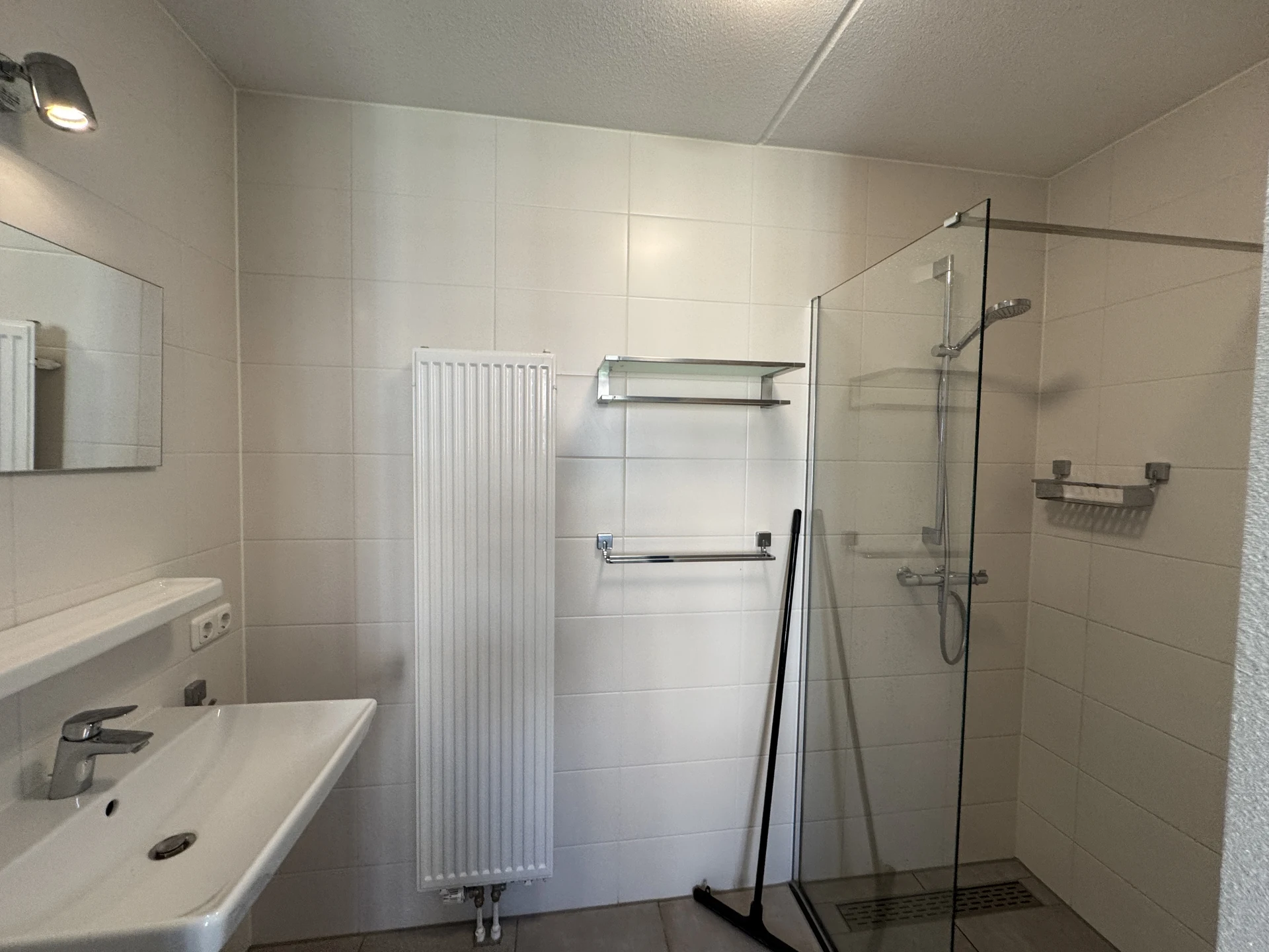 Badezimmer in einem Ferienhaus im Landal Kaatsheuvel mit begehbarer Glasdusche und breitem Waschbecken