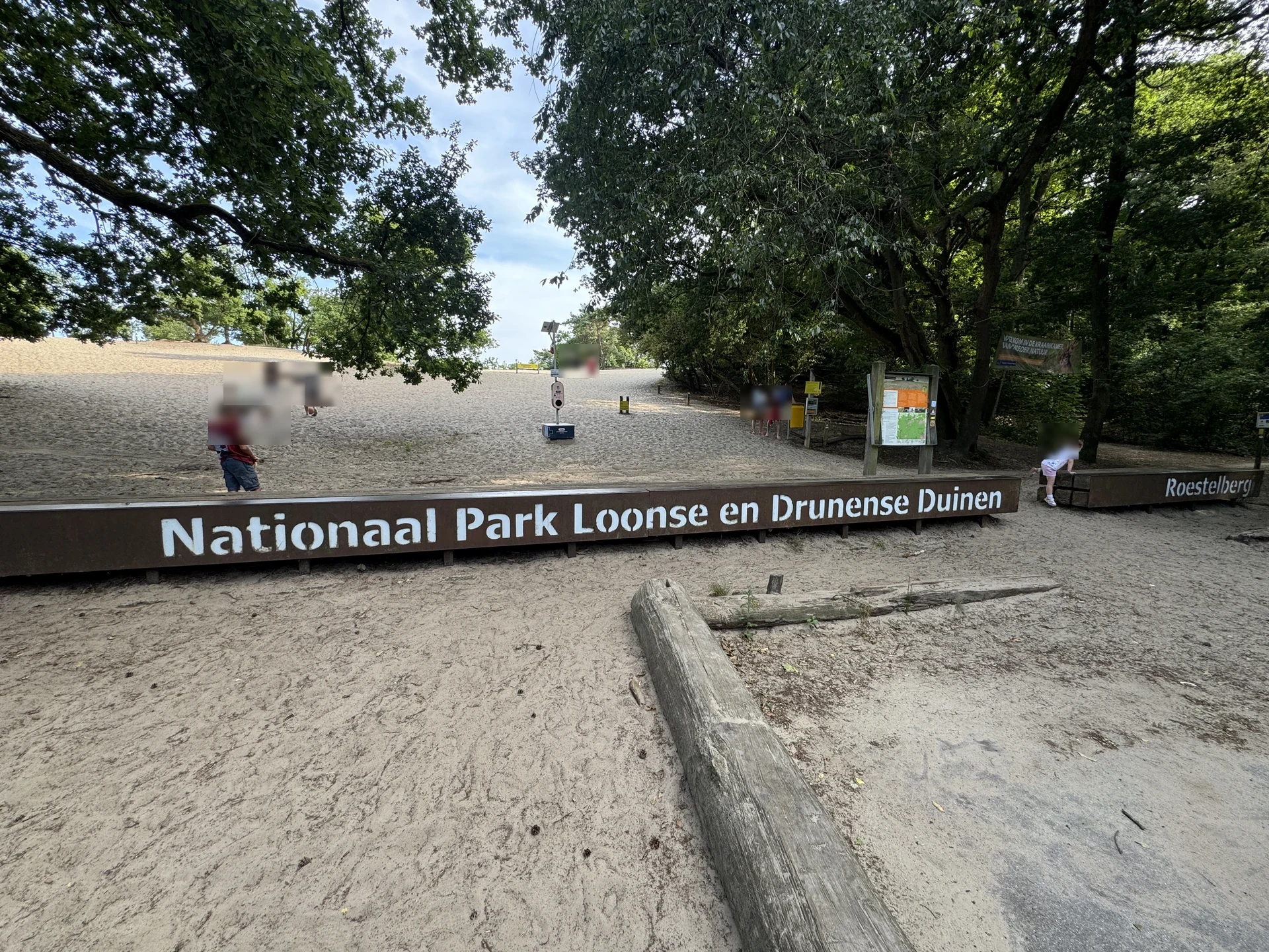 Eingangsschild „Nationaal Park Loonse en Drunense Duinen" am Roestelberg mit Infotafel und dahinter der ansteigenden Sandfläche