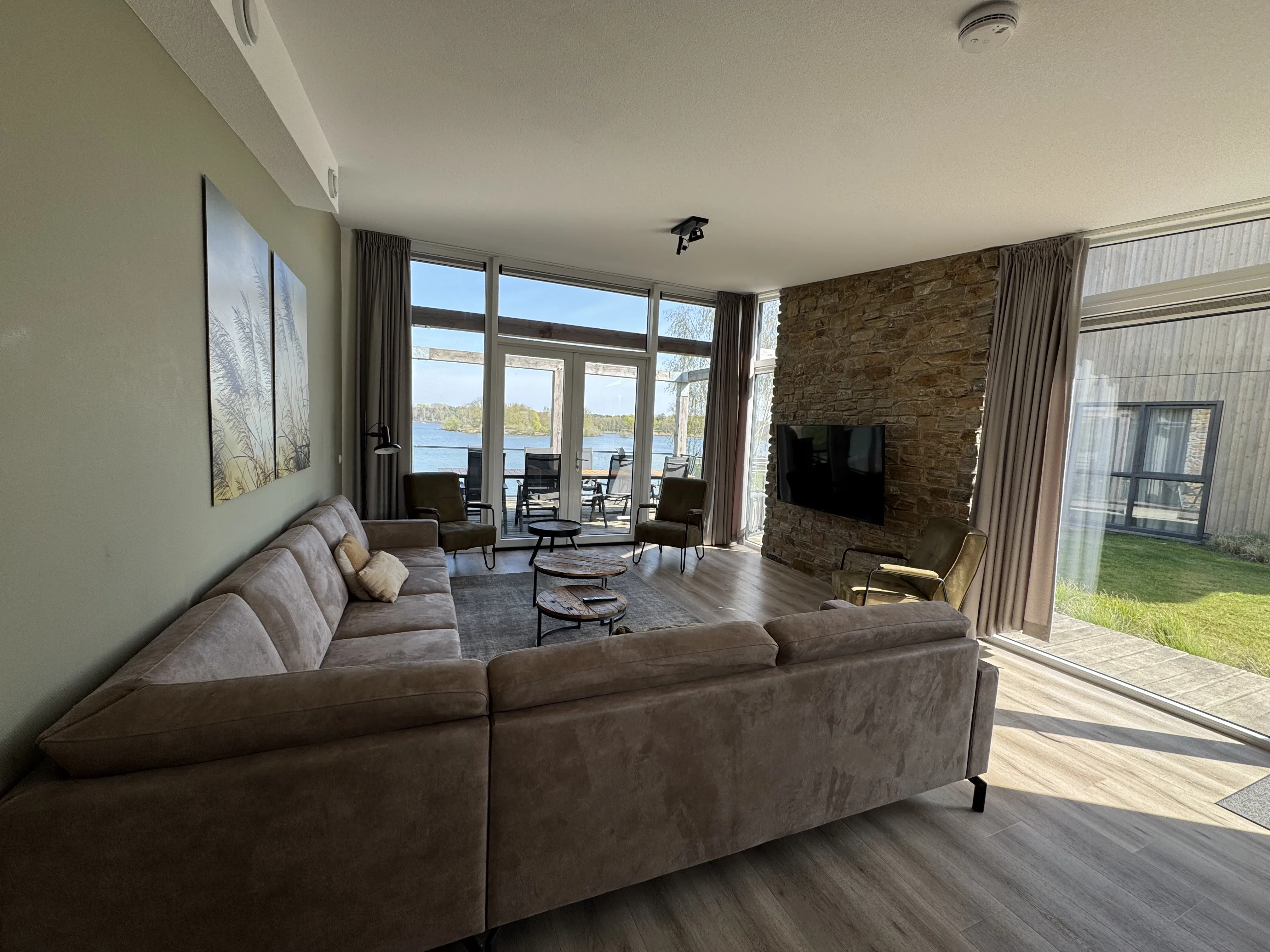 Luxuriöses Wohnzimmer mit Seeblick und Natursteinwand