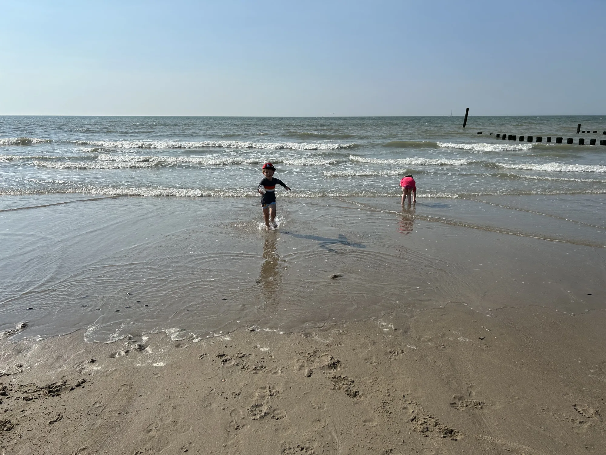 Kinder spielen in den Wellen am Strand von Cadzand-Bad