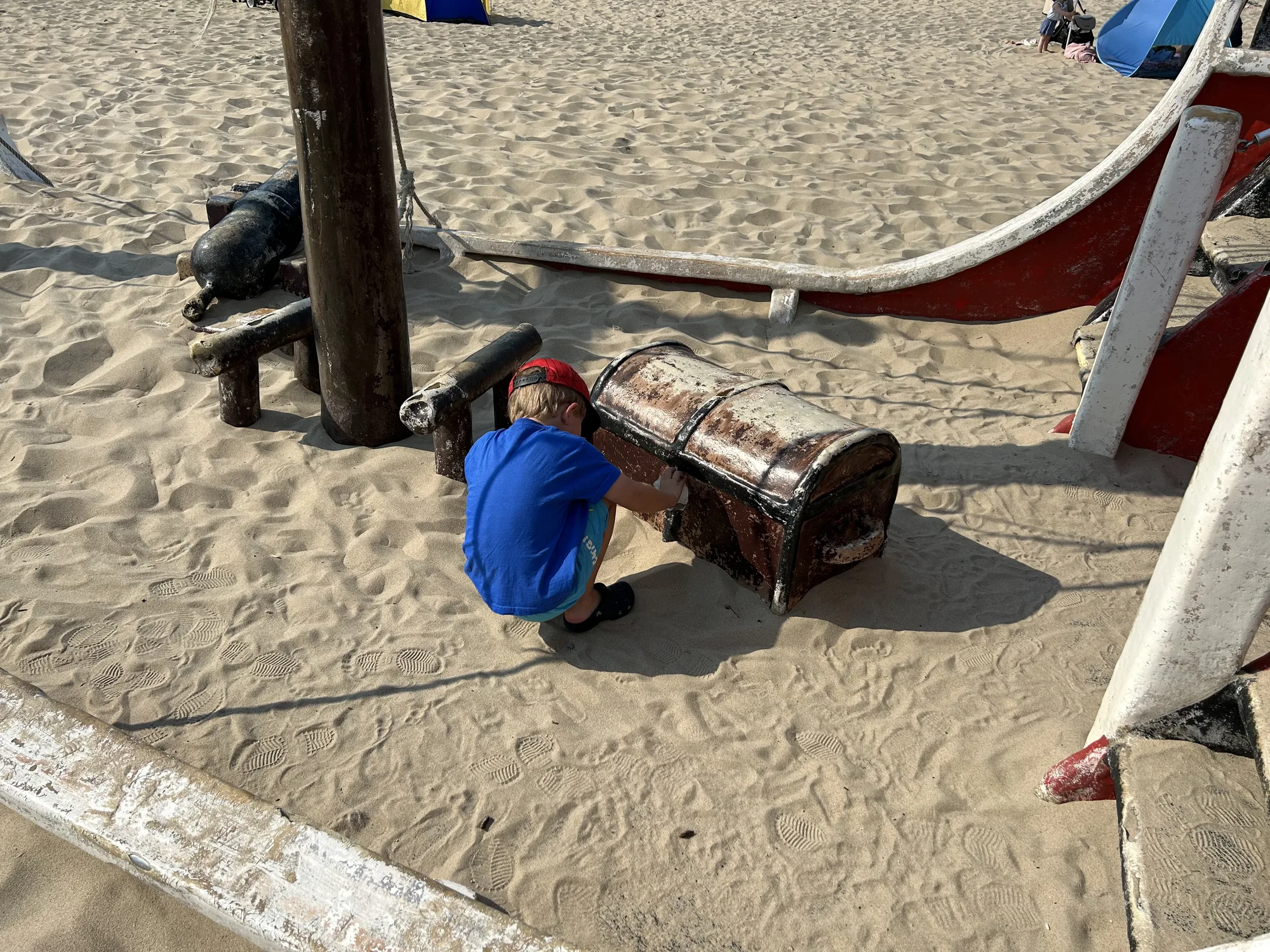 Kind entdeckt die Schatztruhe am Piratenschiff