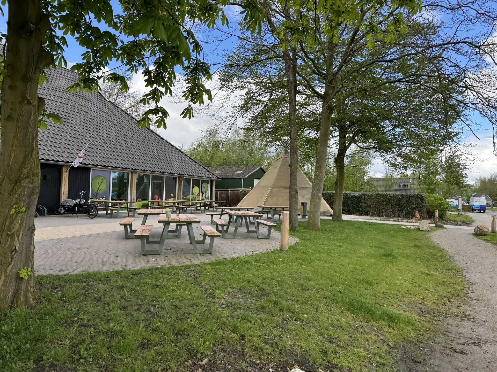 Zentralgebäude des Landal Orveltermarke mit Außensitzflächen und Naturschwimmteich