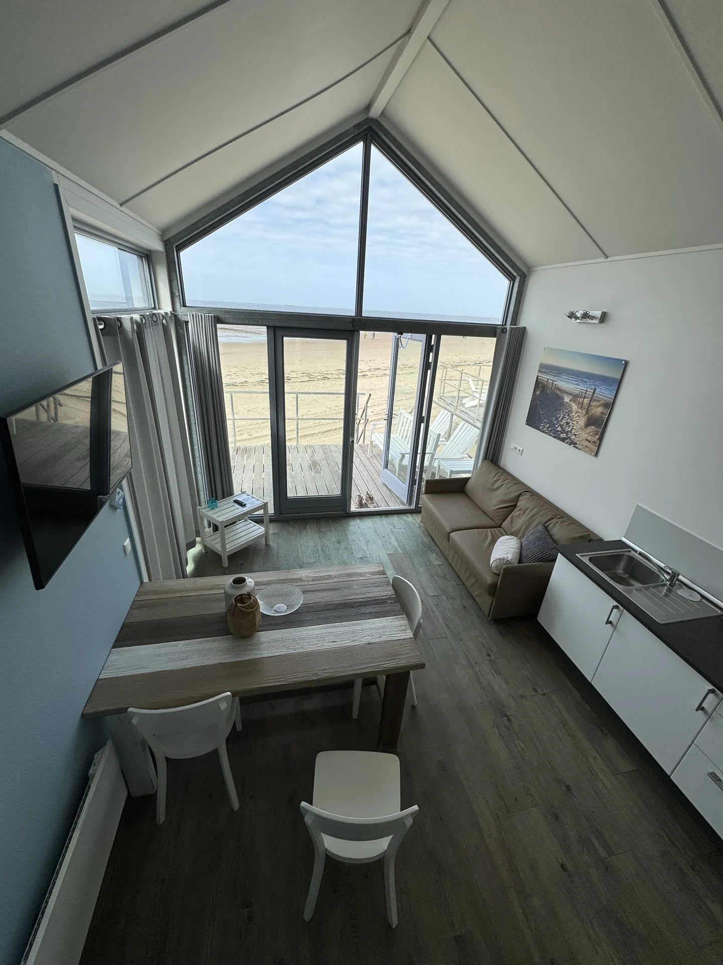 Blick von der Außentreppe eines Strandhäuschens auf Strand und Nordsee in Julianadorp