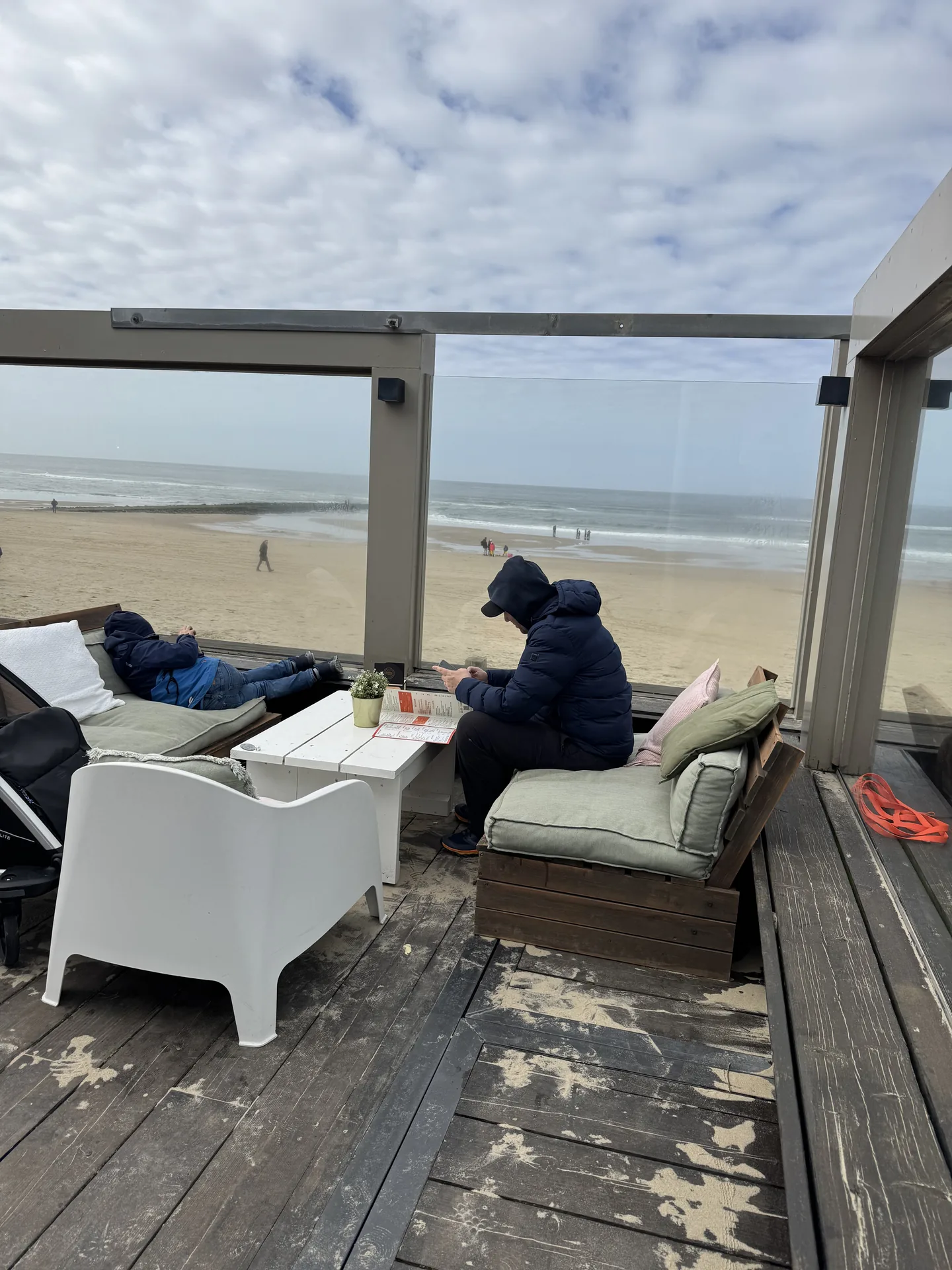 Terrasse des Strandrestaurants in Julianadorp mit Familie bei Kaffee
