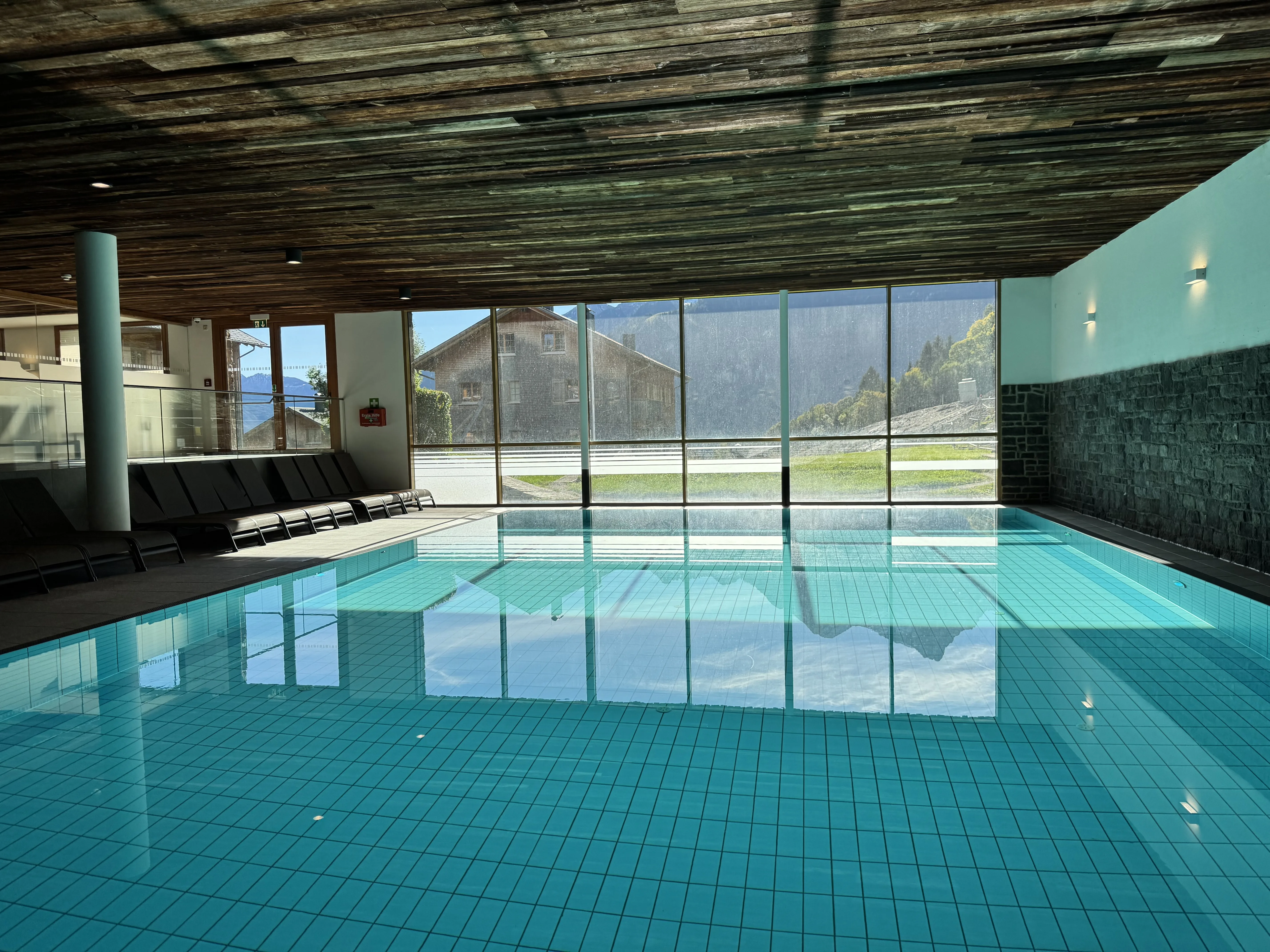 Blick über das Becken auf die Berge und die Ferienanlage