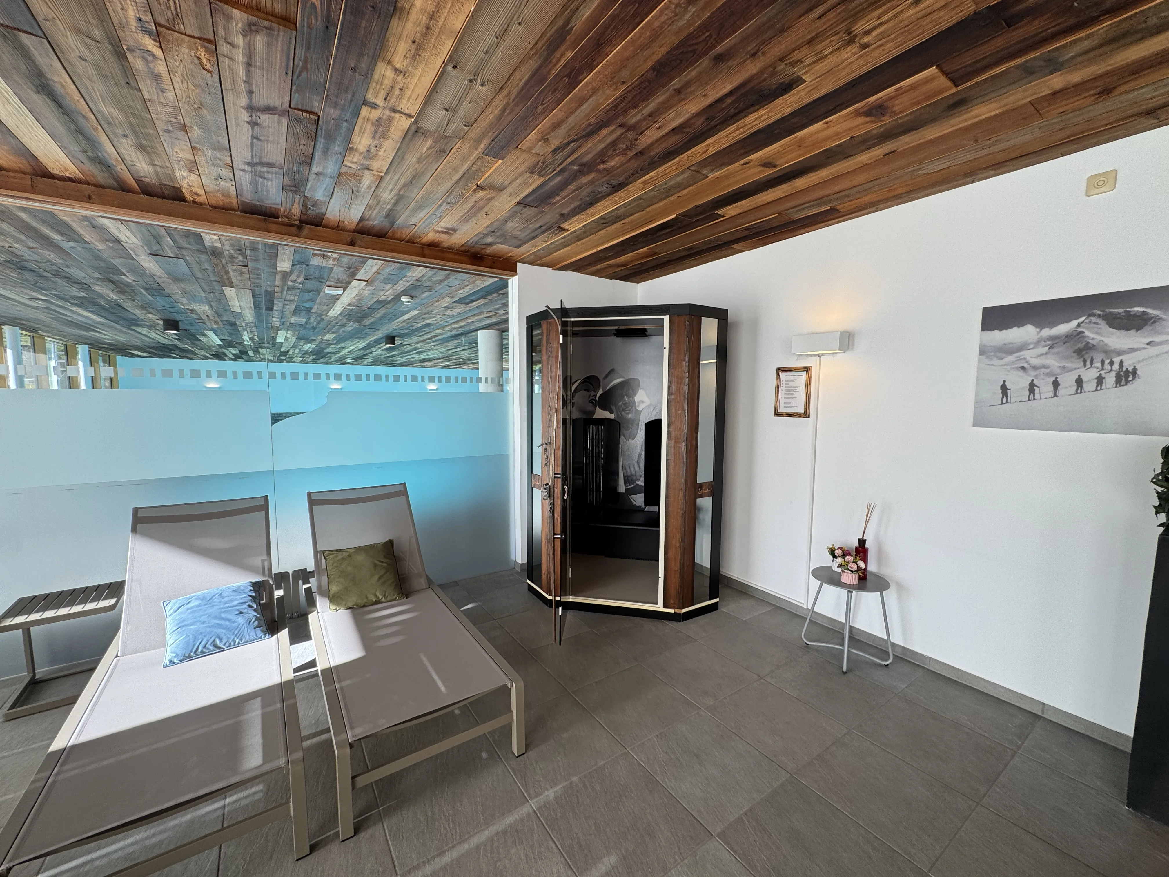 Ruhebereich mit Infrarotkabine und Blick aufs Schwimmbad