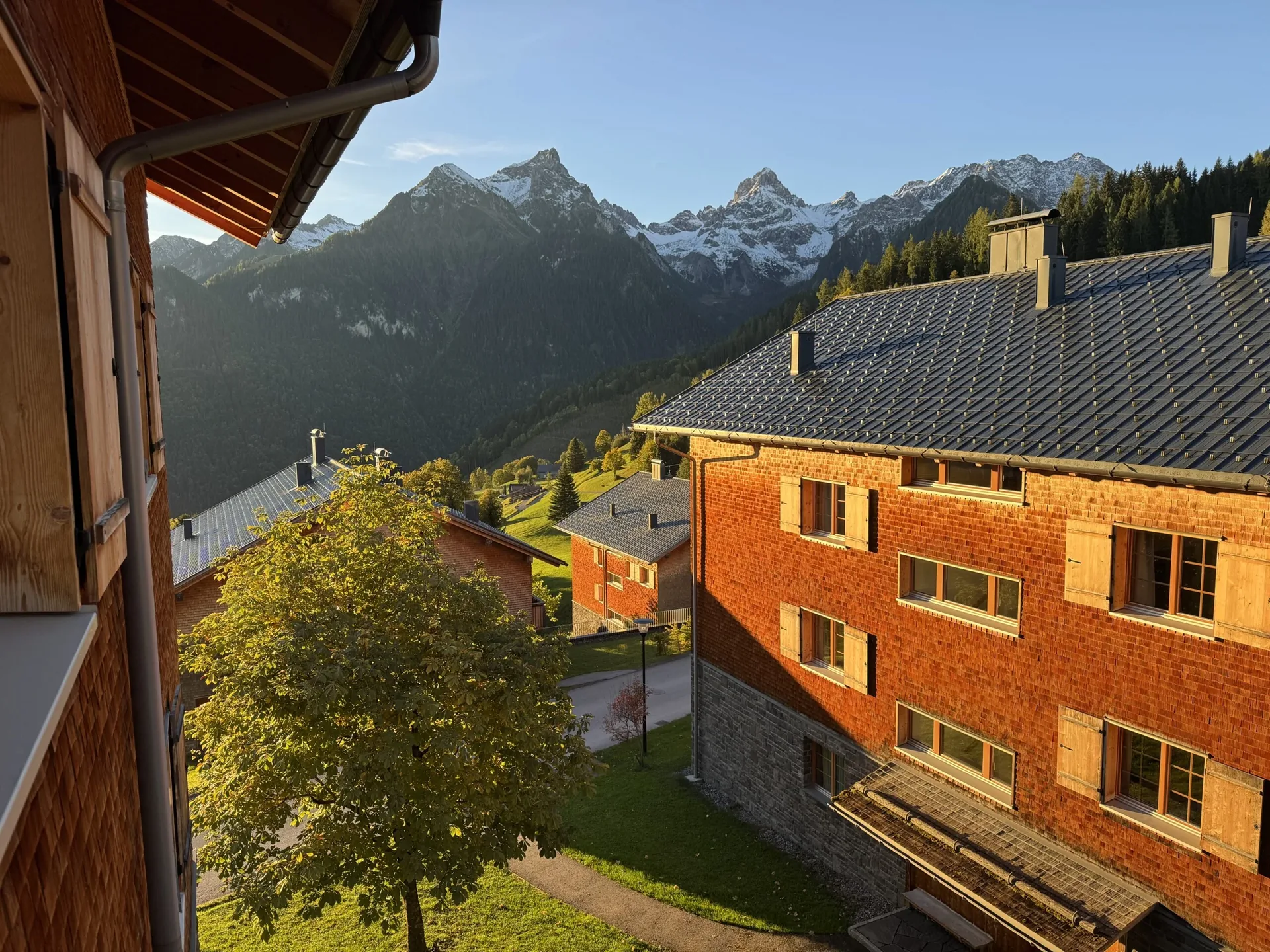 Balkonblick auf die Alpen-Chalets im Landal Brandnertal im Abendlicht mit Bergen