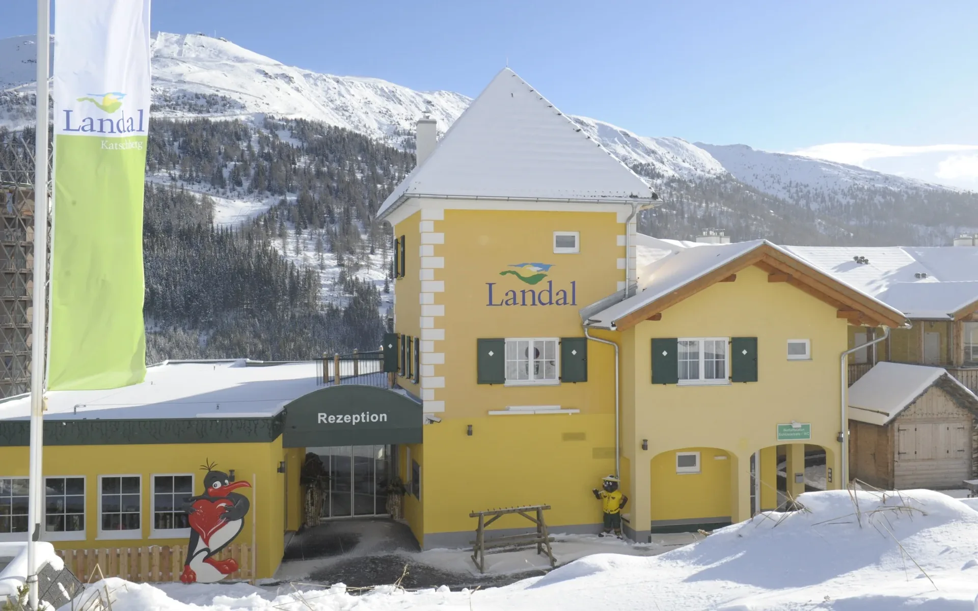 Rezeption des Landal Katschberg mit Bollo-Maskottchen und Blick auf die Skipiste