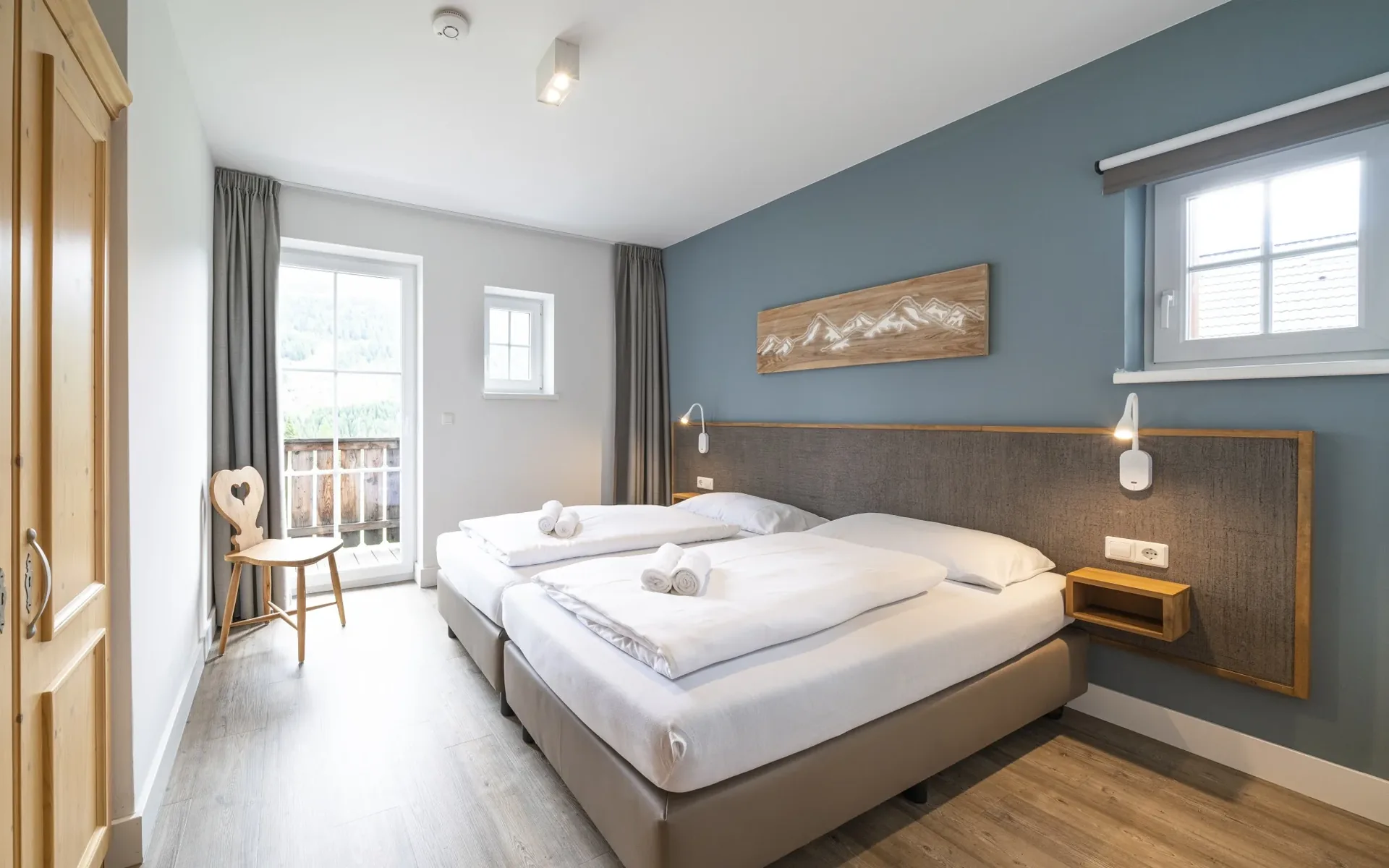 Schlafzimmer mit Doppelbett und Balkon in einer Landal Katschberg Ferienwohnung mit Bergblick