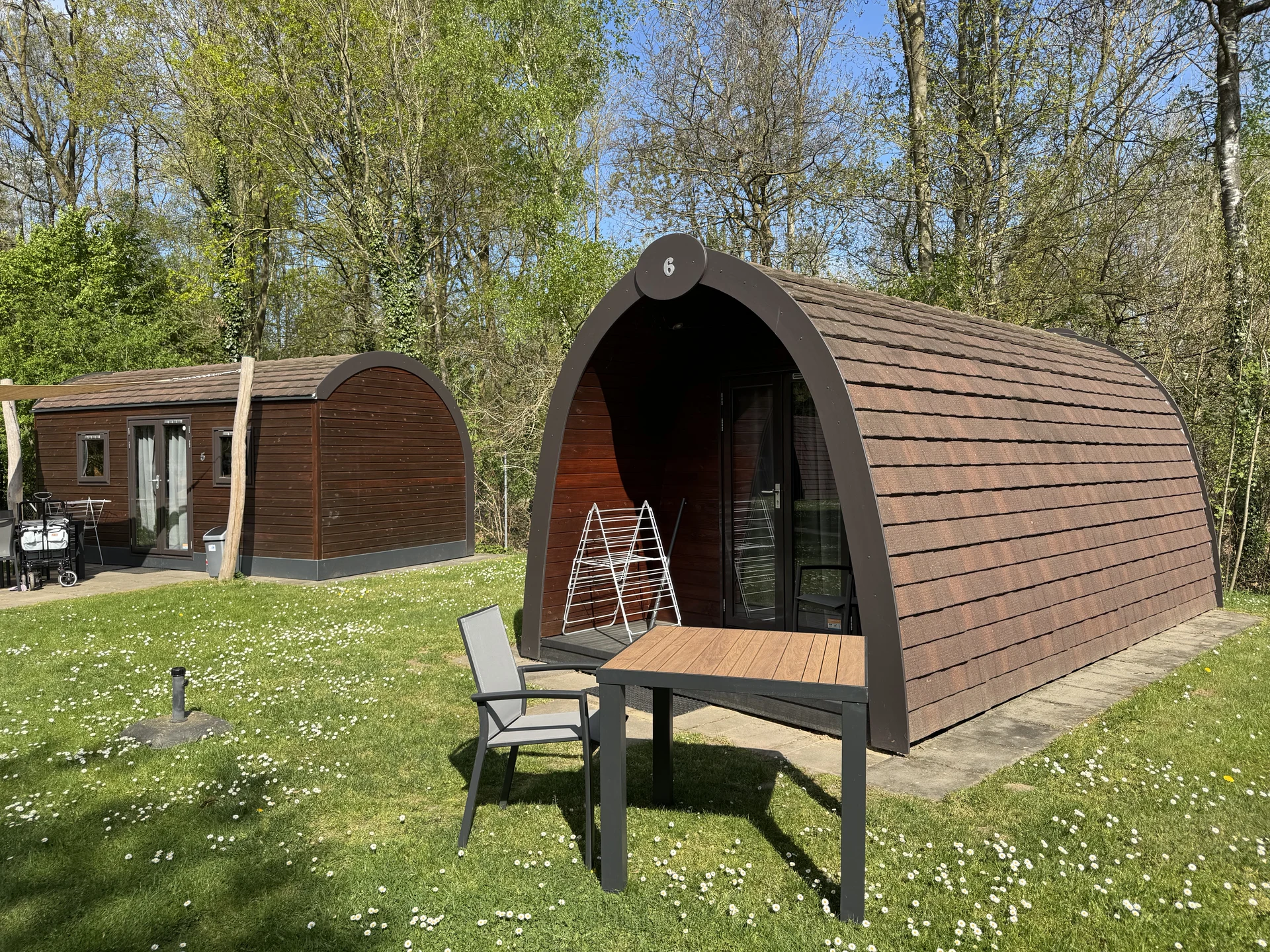 Holz-Pods auf der Wiese des Campingplatzes