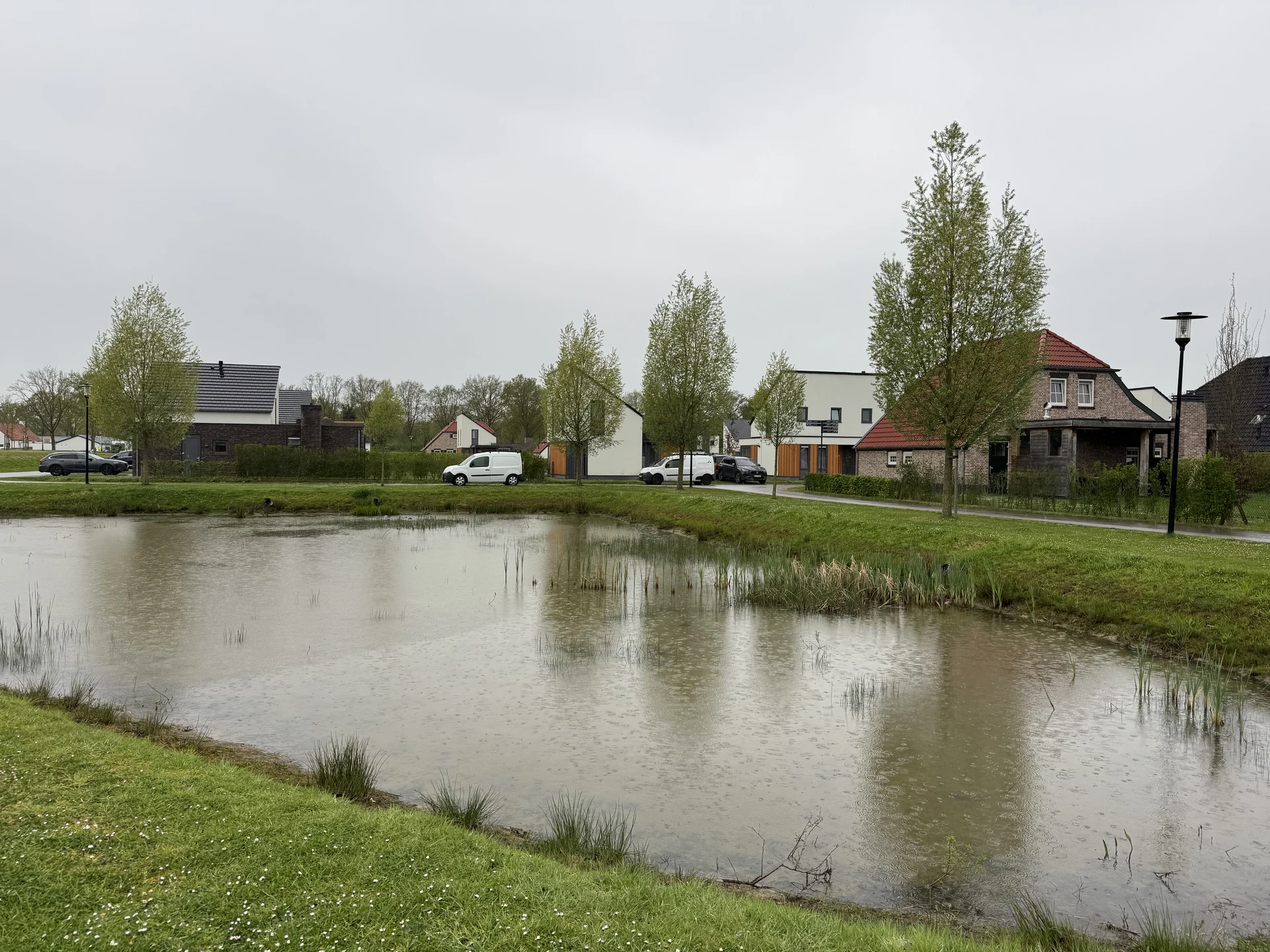 Moderne Ferienhäuser mit weißer Fassade und Holzelementen am Teich im Bungalowpark