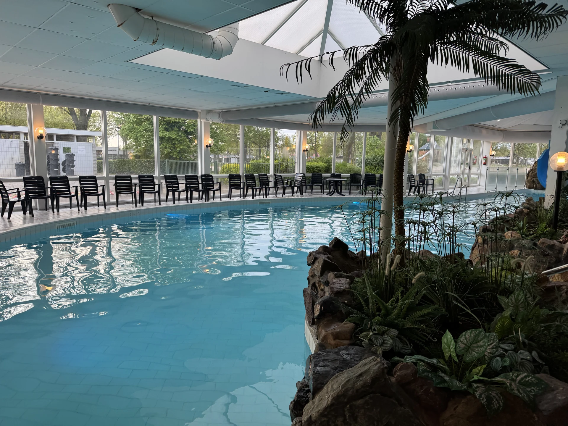 Lagunenbecken mit Palmeninsel unter dem Glasdach