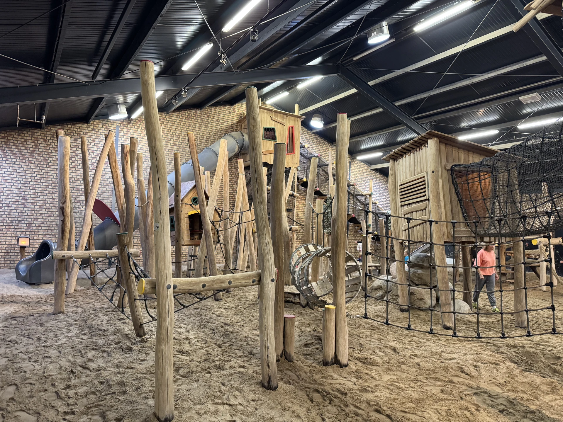 Kletterbereich aus Holzstämmen mit Netzen und Hütten