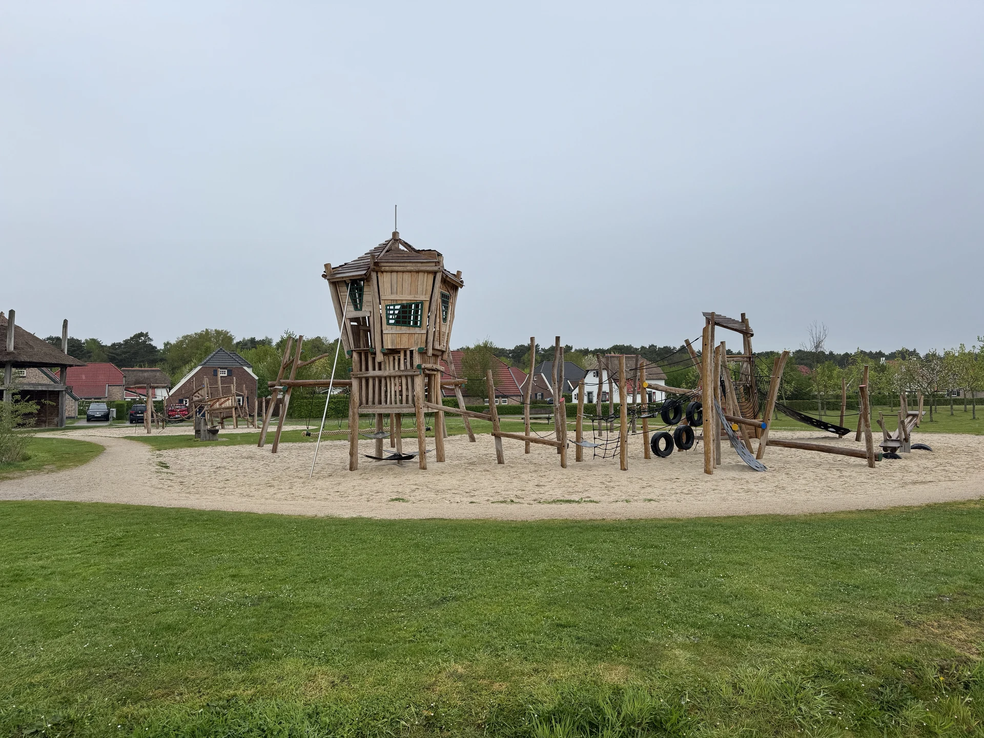 Spielplatz mit Holzturm zwischen den Häusern im Bungalowpark