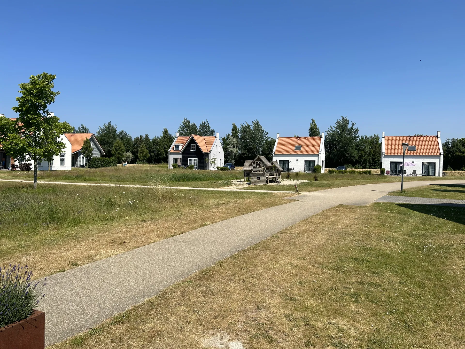 Ferienhäuser am Park-See mit kleinem Holz-Spielplatz im Vordergrund