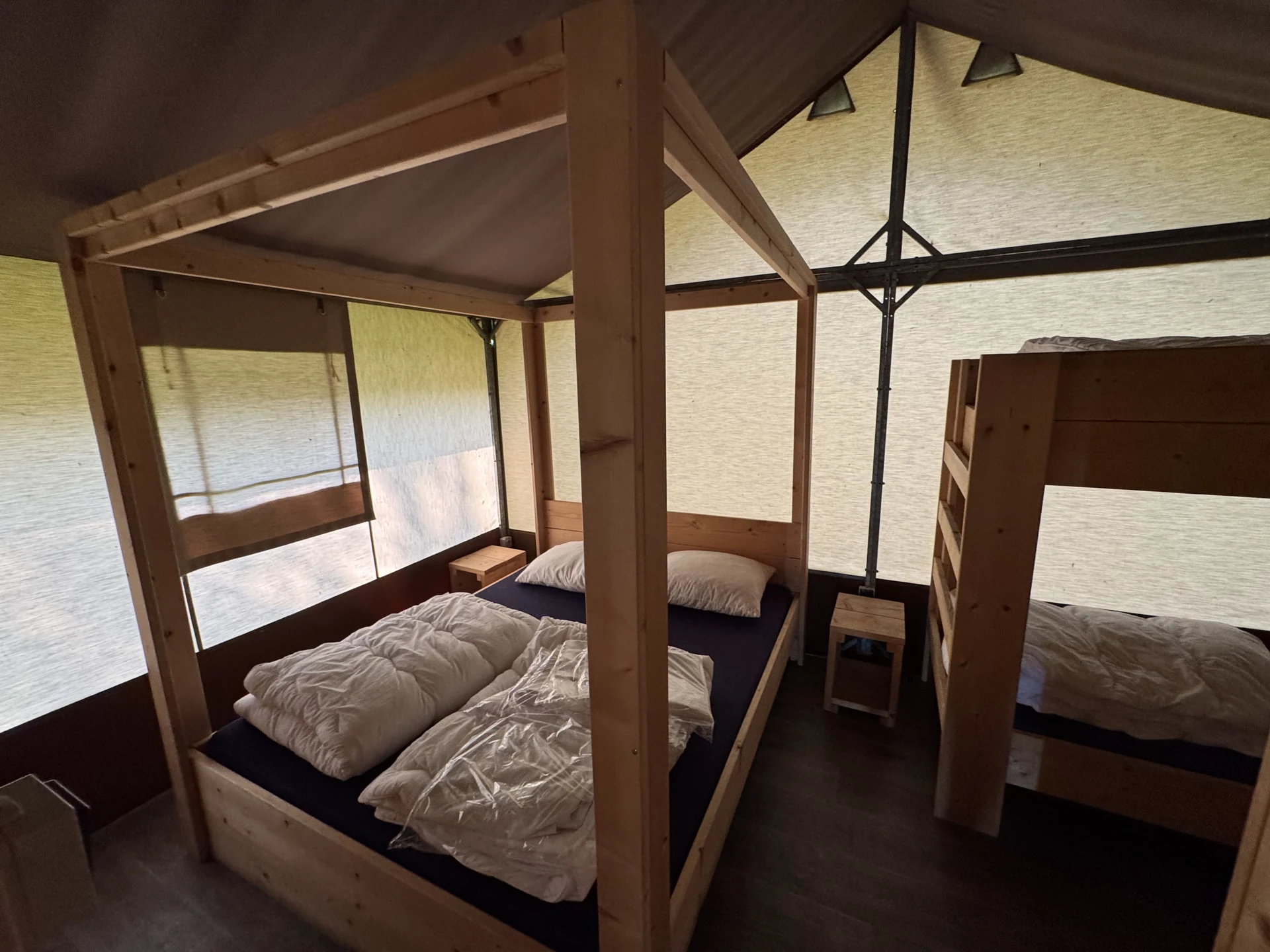 Innenansicht eines Safari-Zelts im Lake Resort Beekse Bergen mit Holz-Himmelbett, Etagenbett für die Kinder und Stoffwänden