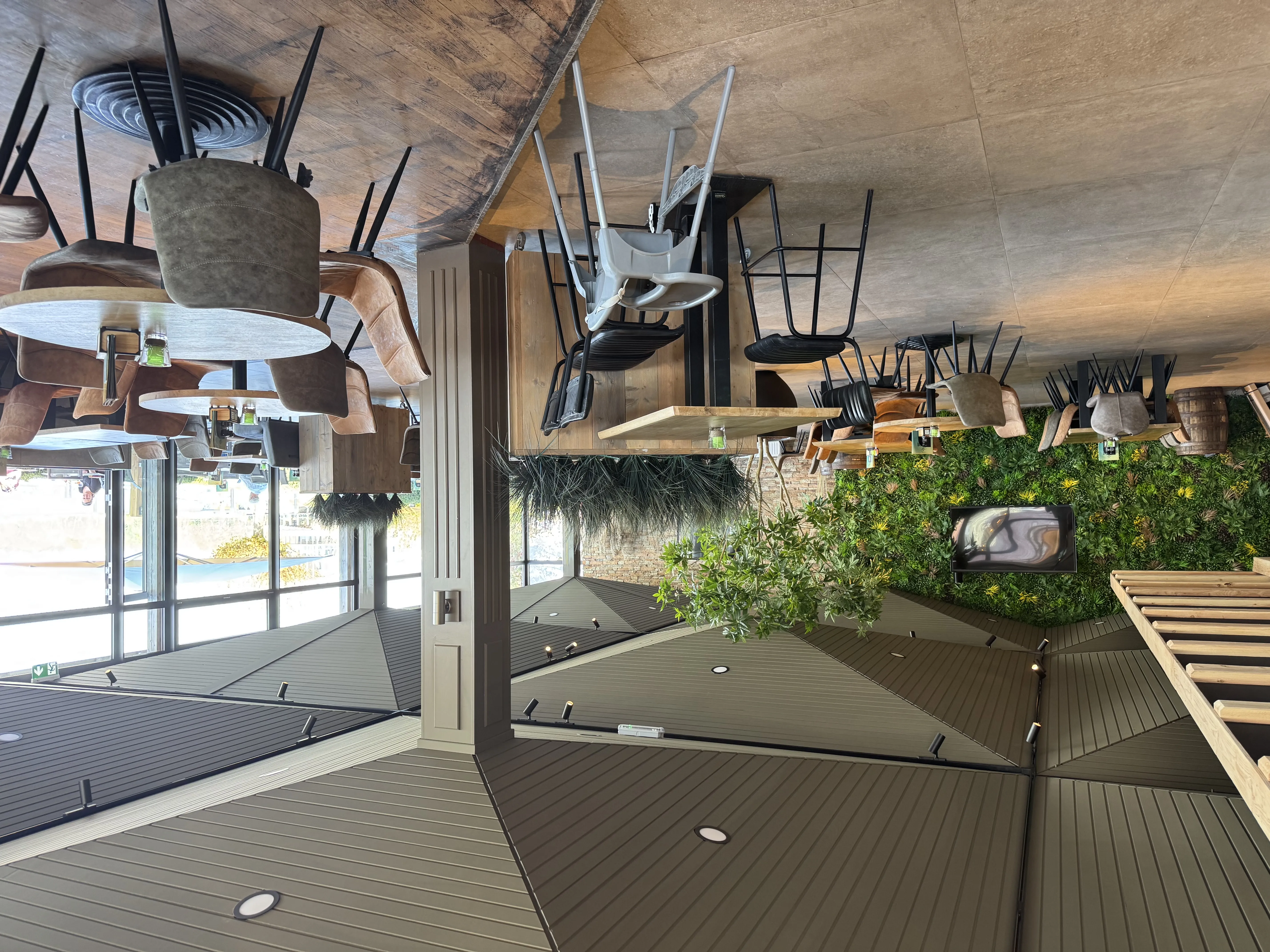 Innenbereich des Beach Clubs mit stilvoller Einrichtung und Pflanzenwand